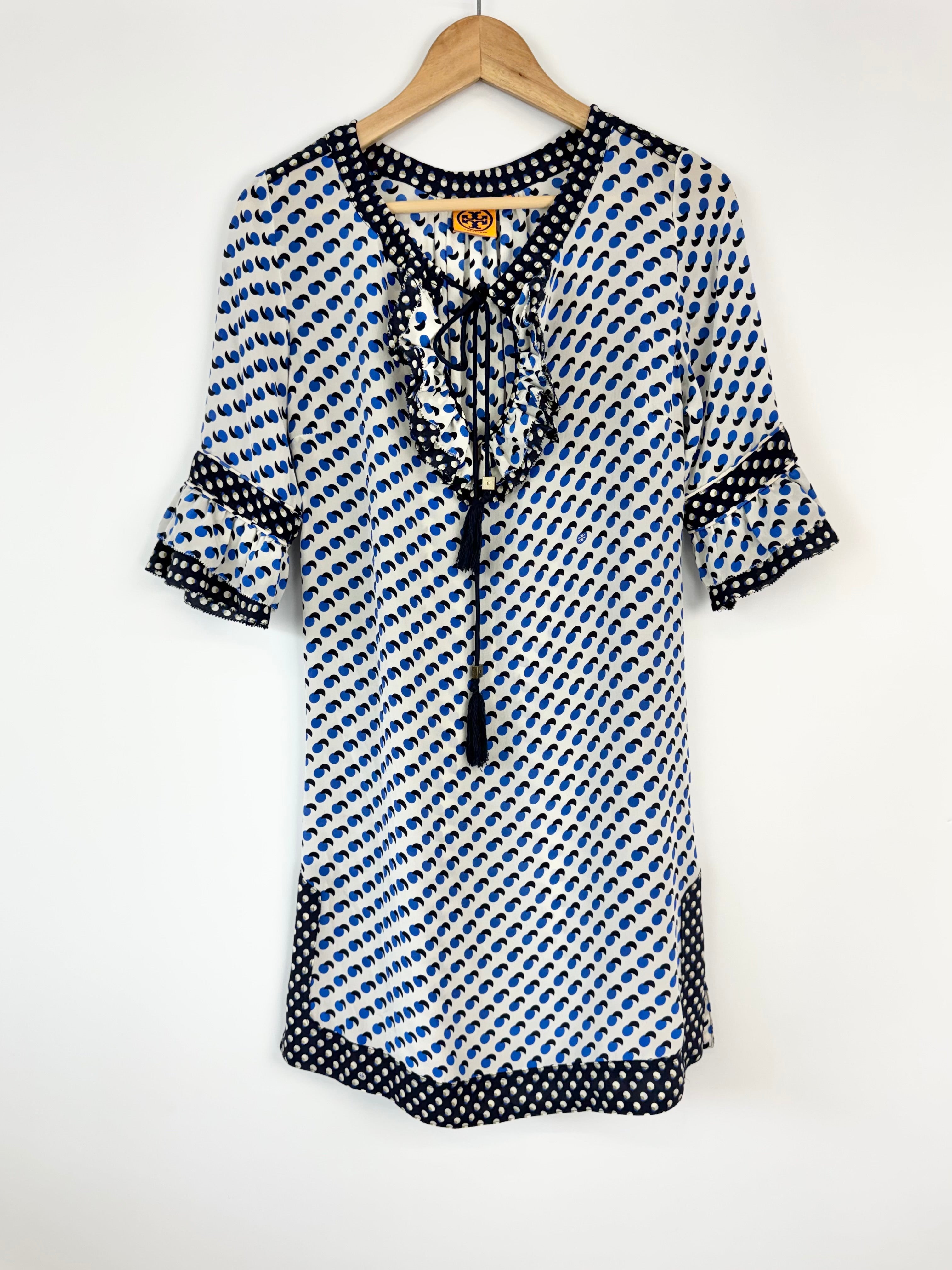 Black and white patterned dress on a hanger against a white background