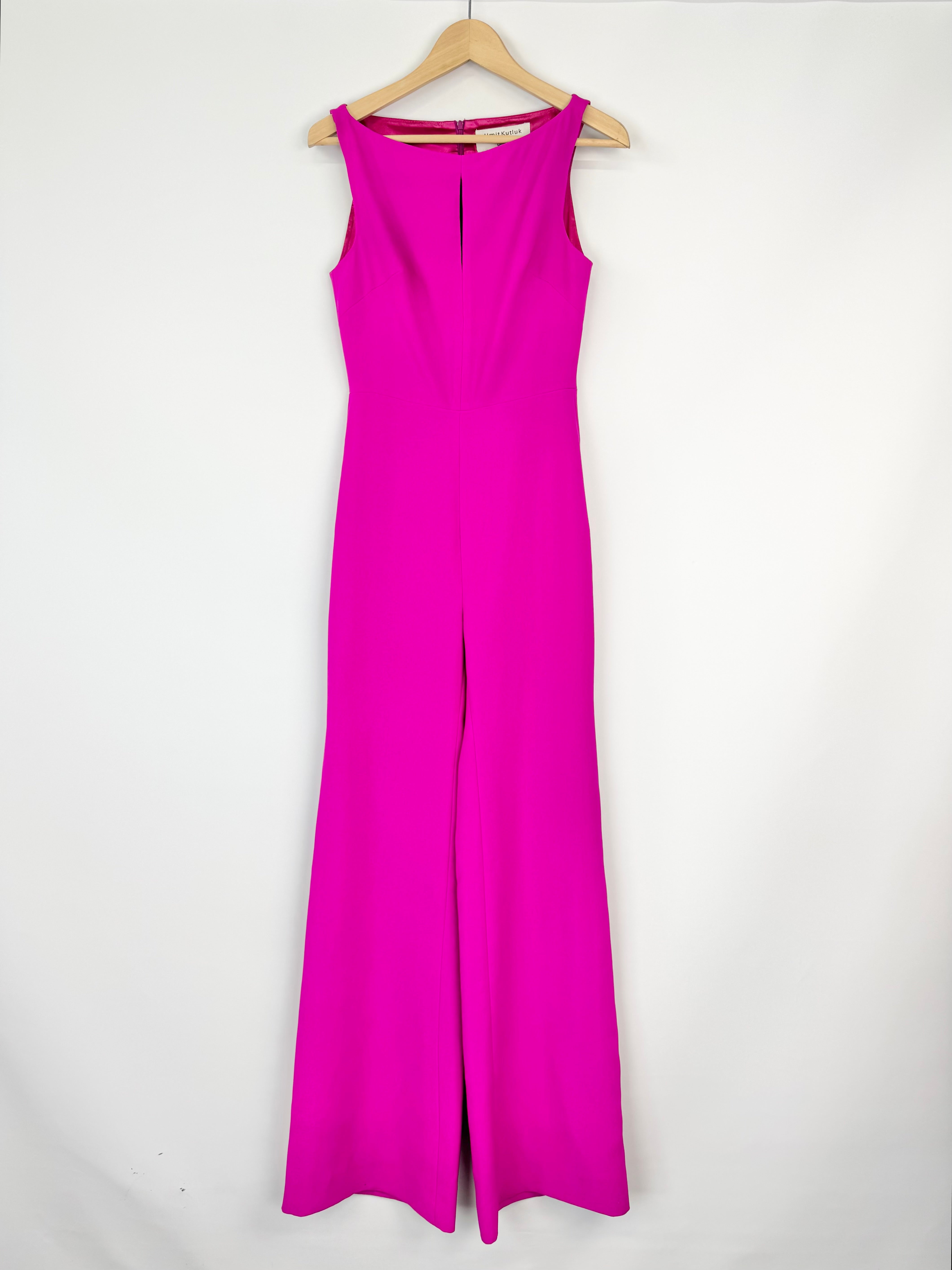 Pink jumpsuit on a hanger against a white background