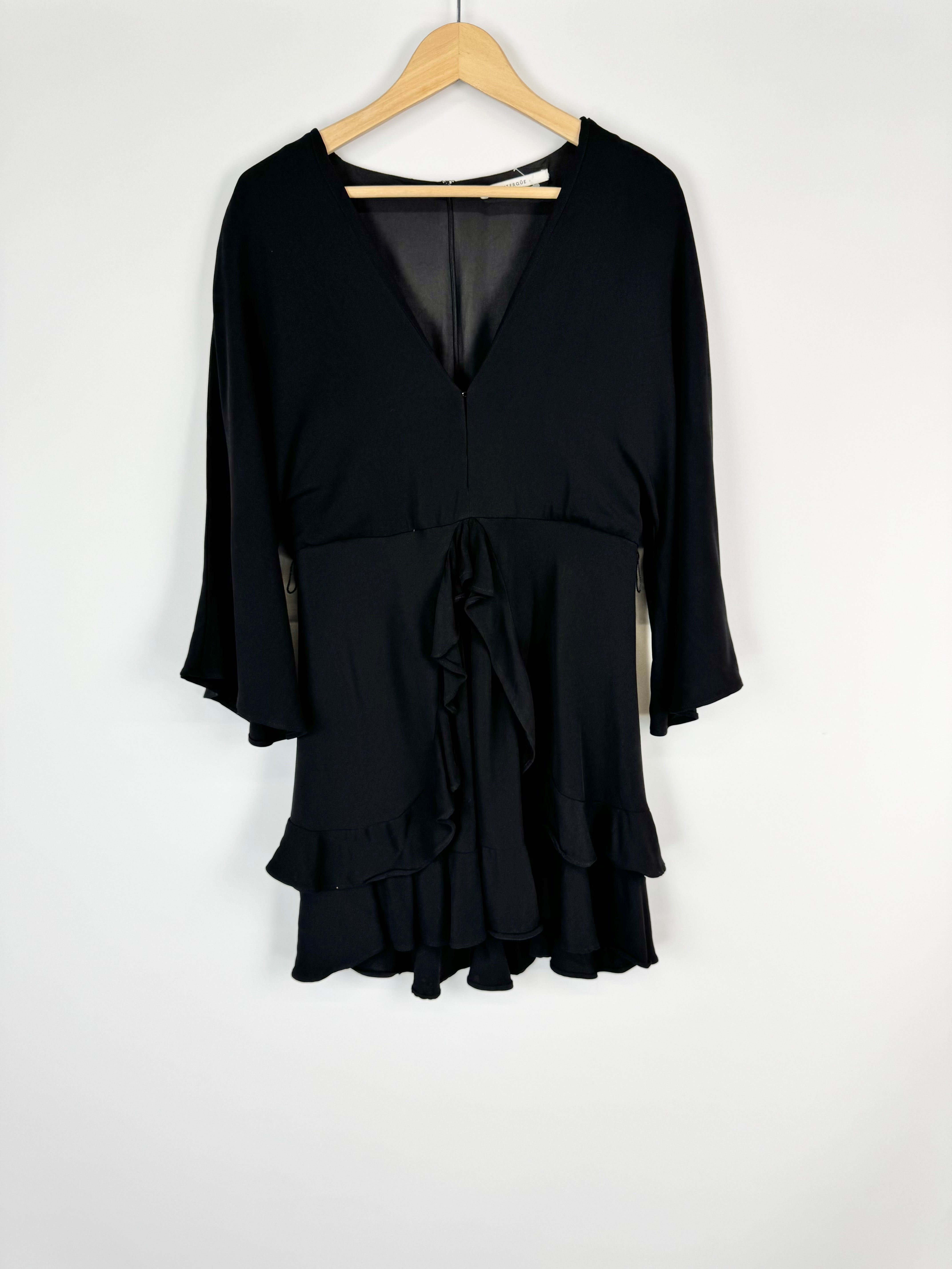 Black dress on a wooden hanger against a white background