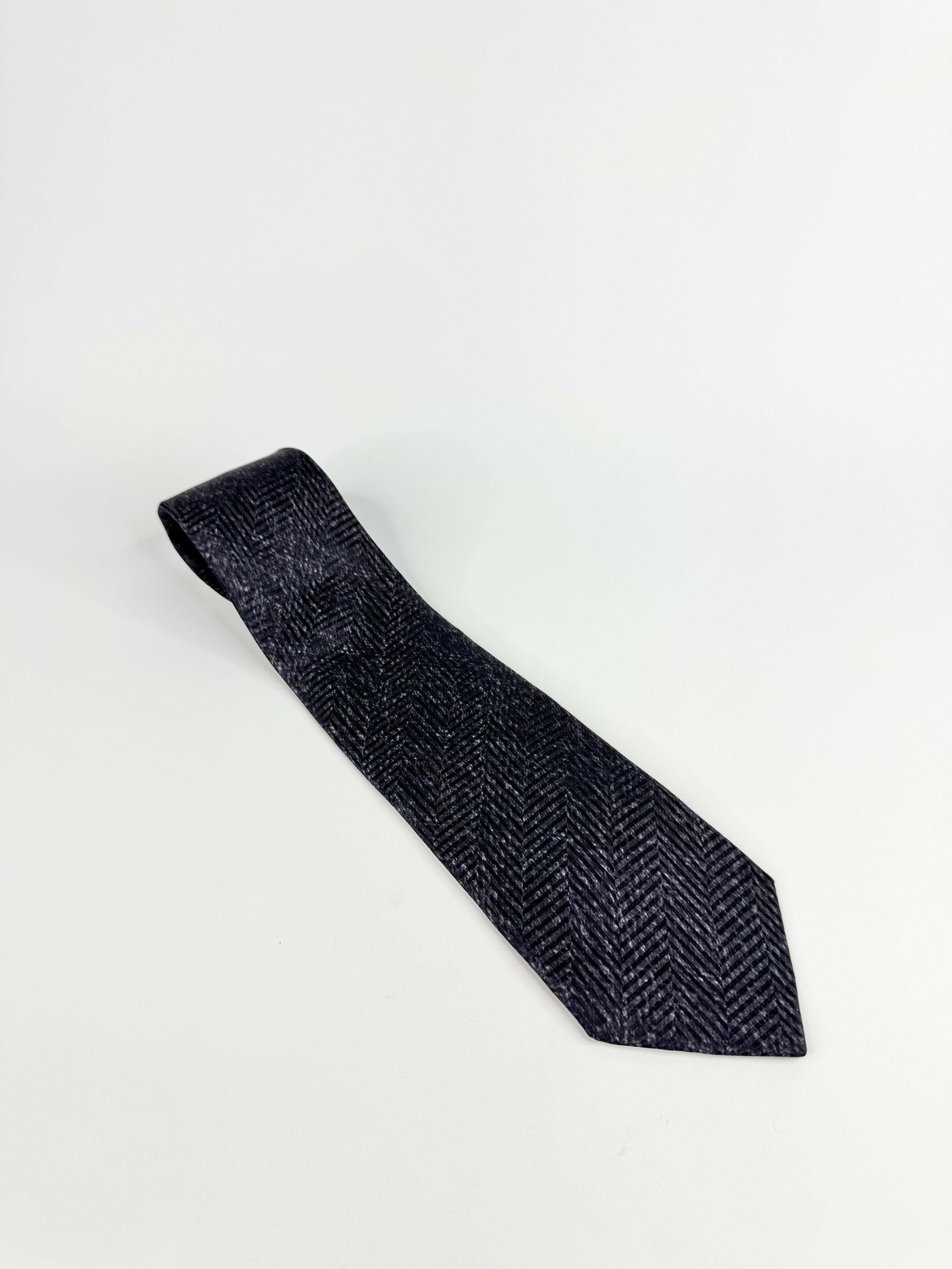 Black textured tie on a light gray background