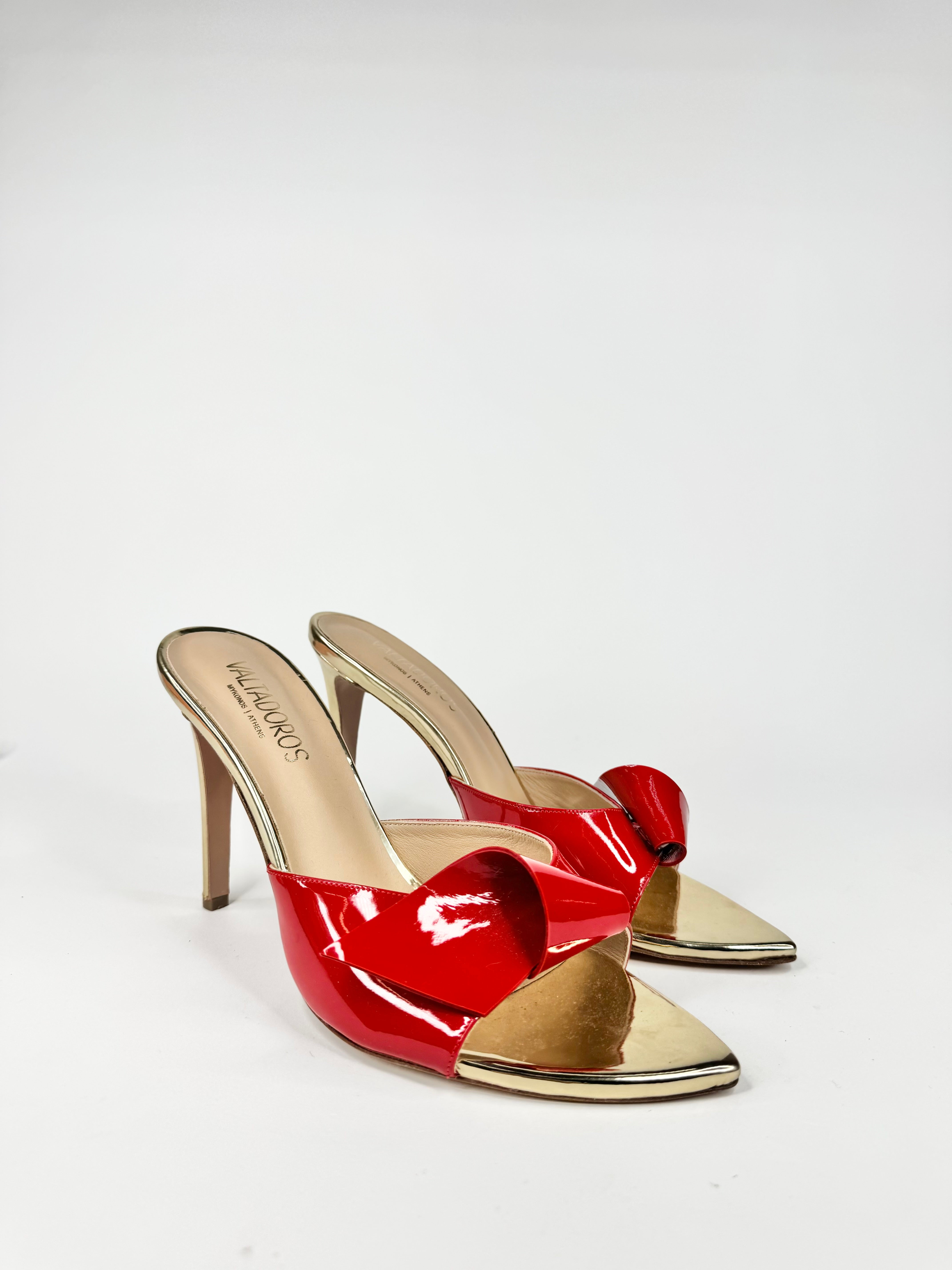 Red high-heeled shoes with gold accents on a white background