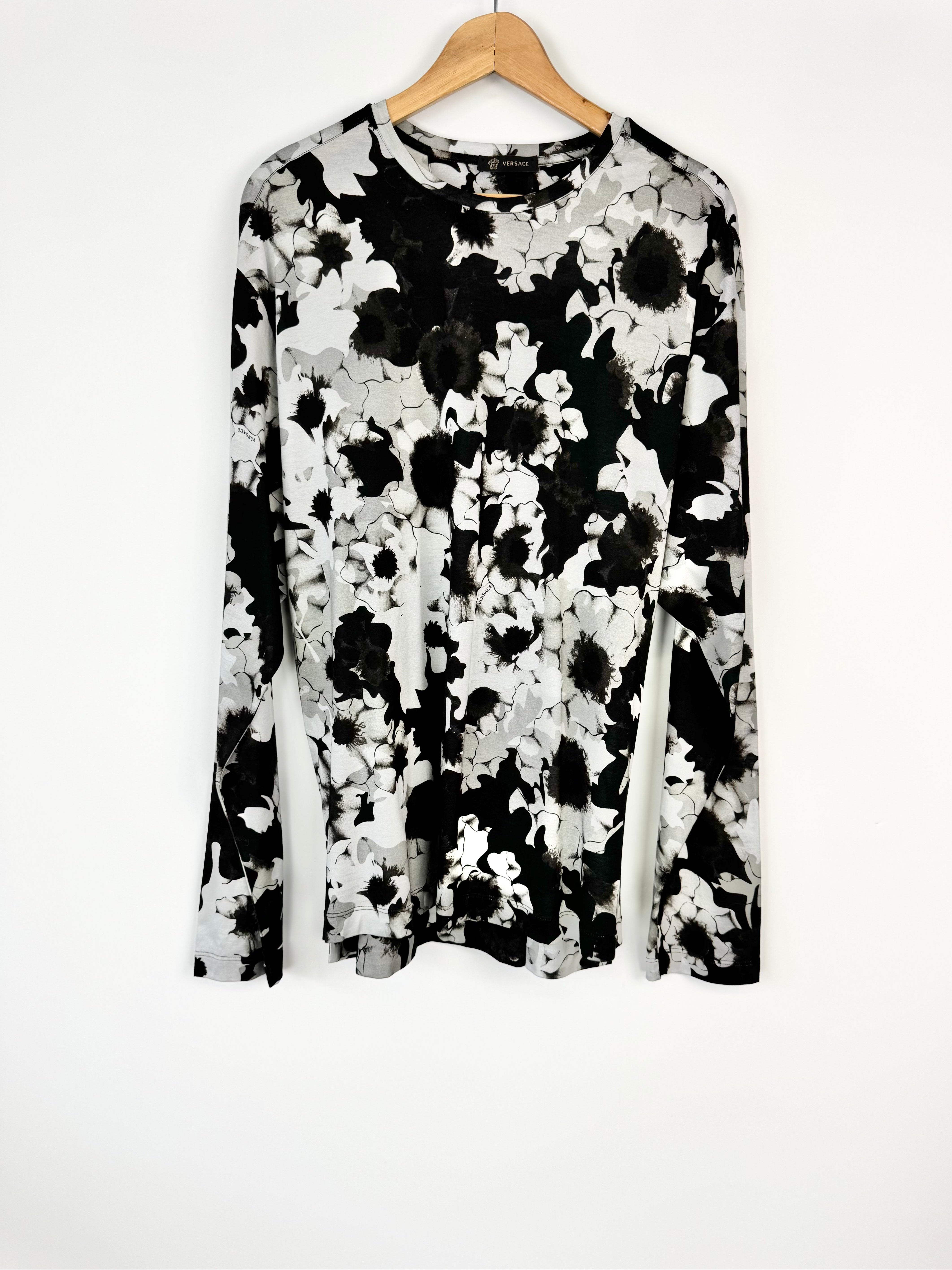 Black and white floral patterned top on a hanger against a white background