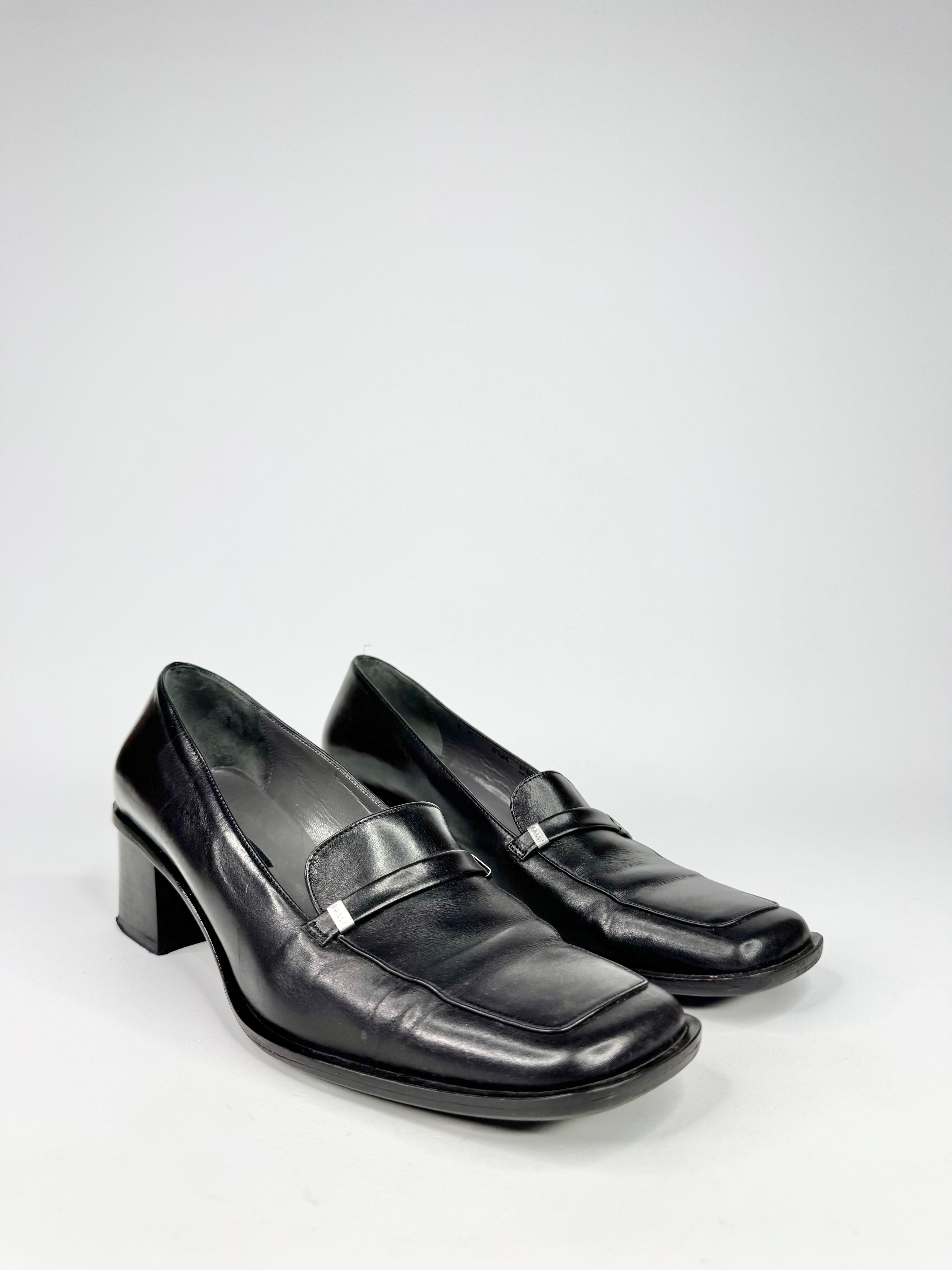 Pair of black leather loafers on a white background