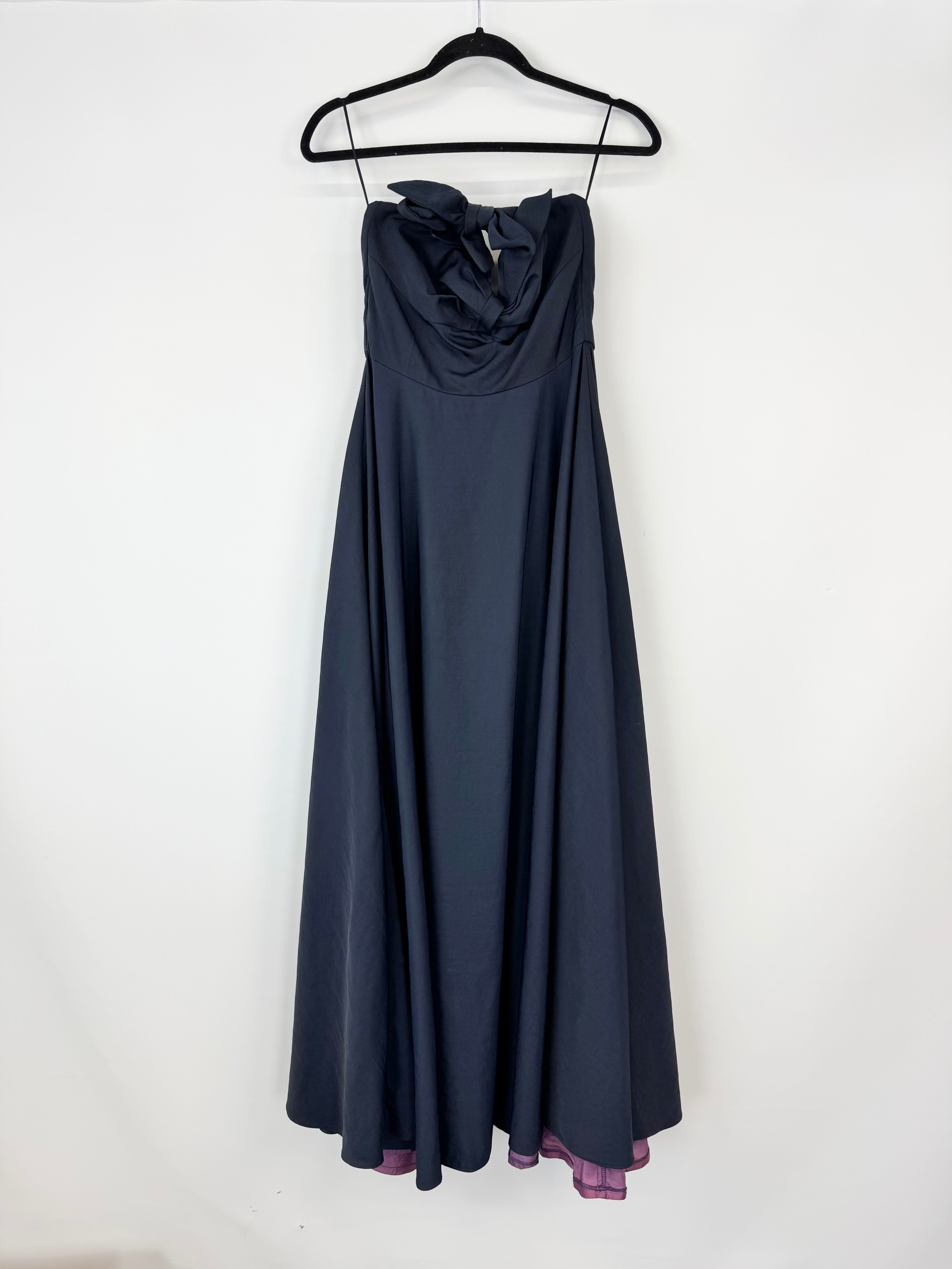 Navy blue strapless dress on a hanger against a white background