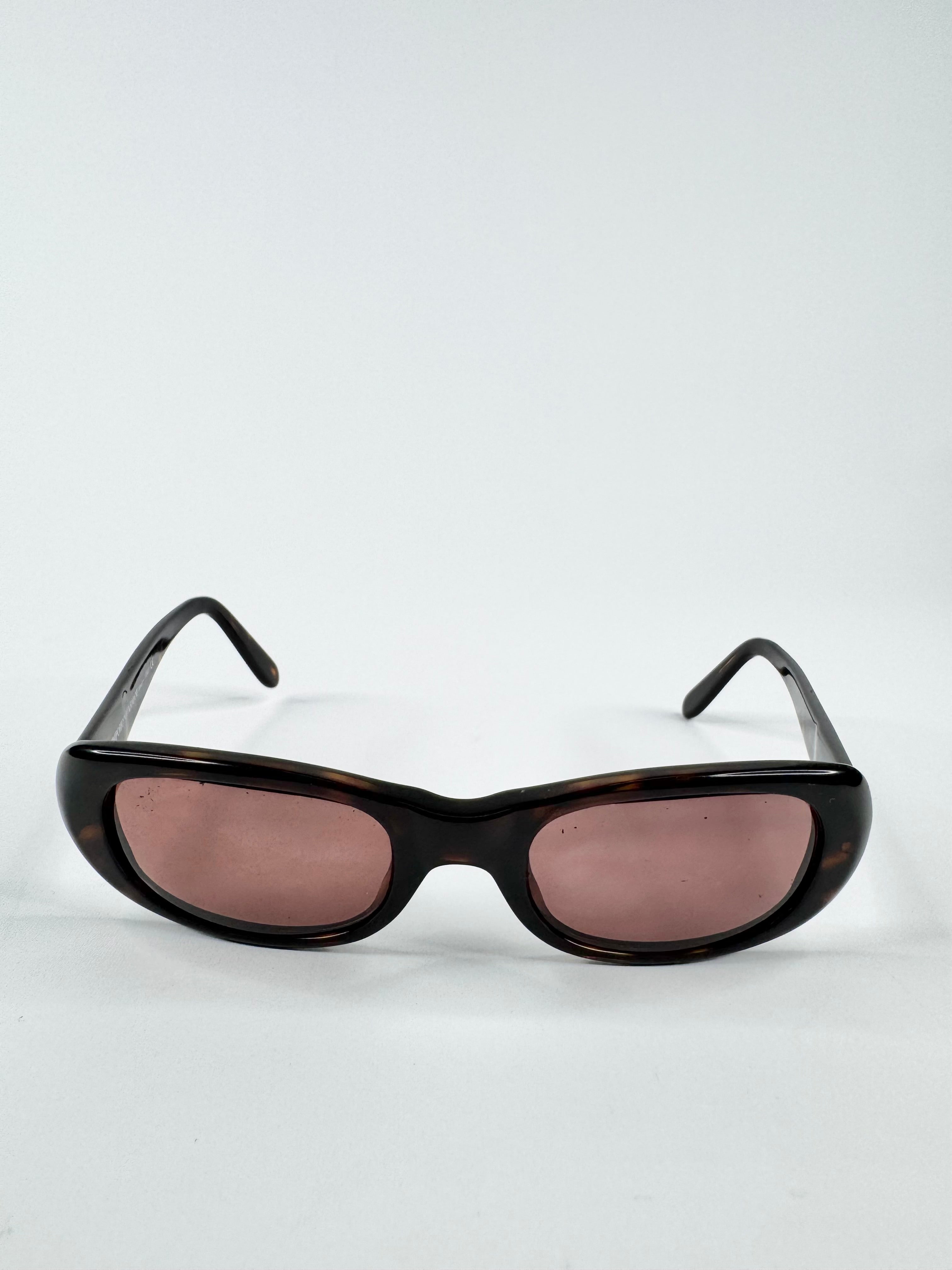 Sunglasses with tortoiseshell frame and pink lenses on a white background