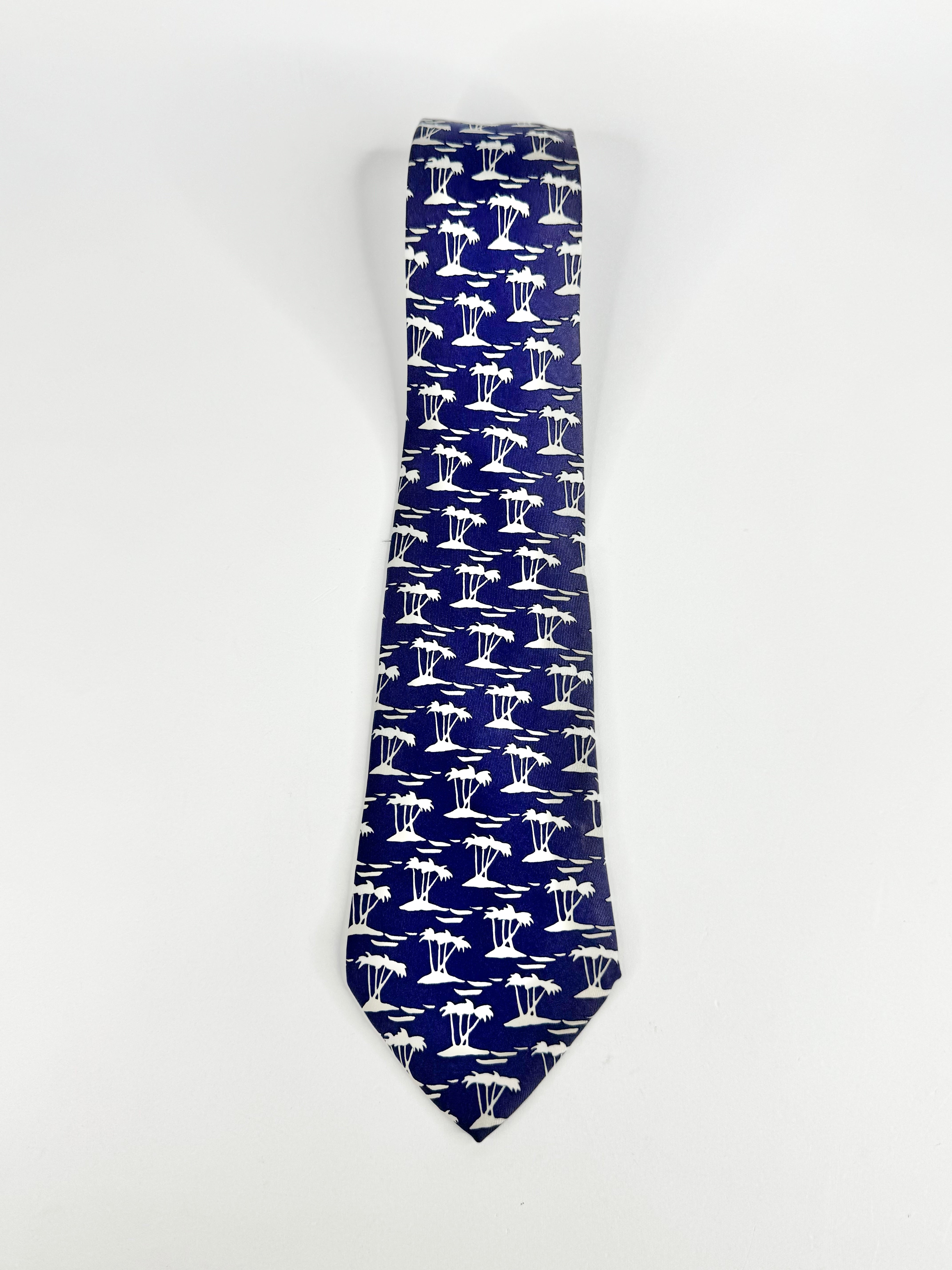 Navy blue tie with palm island patterns on a white background