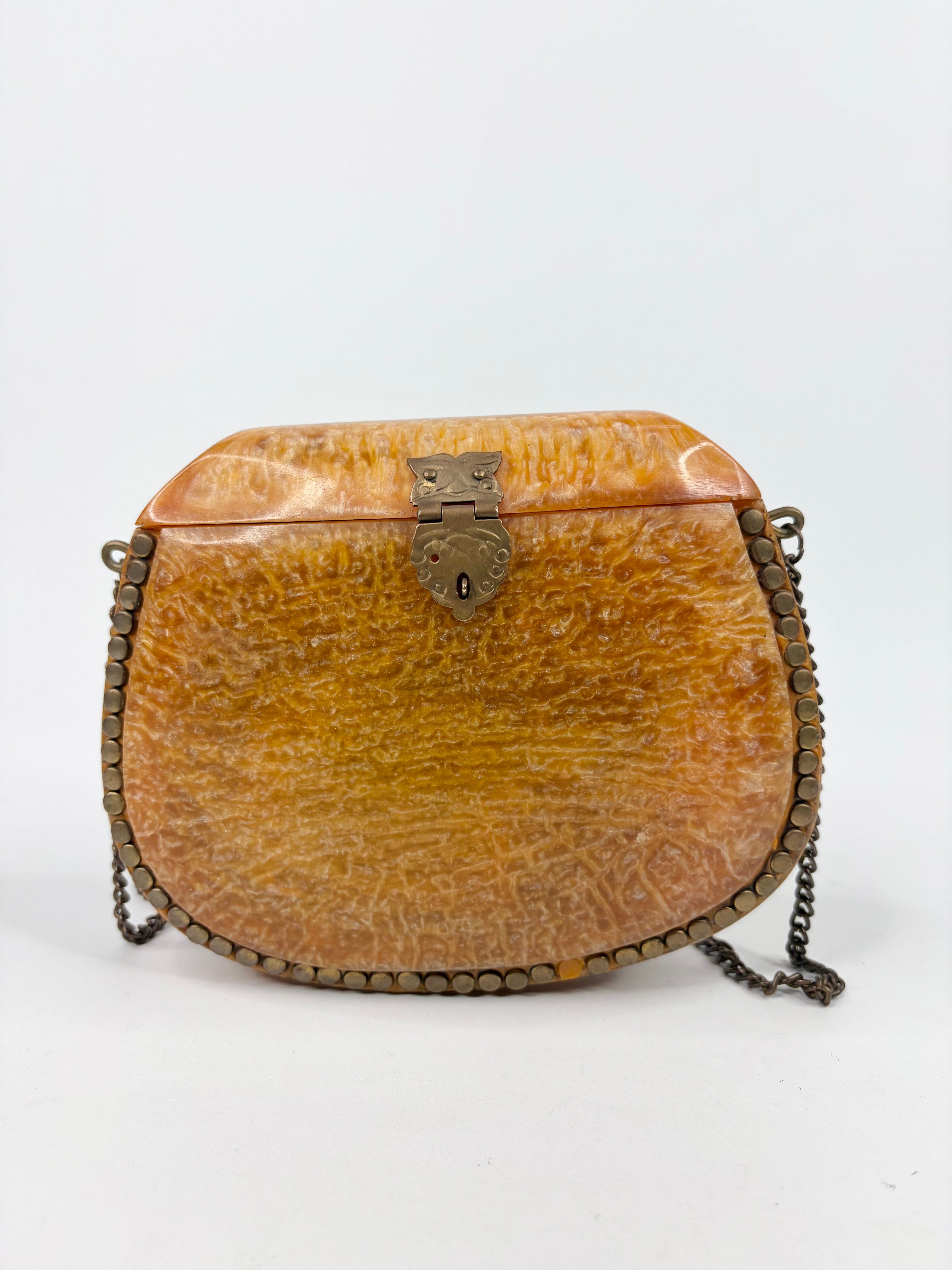 Vintage-style handbag with a textured surface and chain strap on a white background