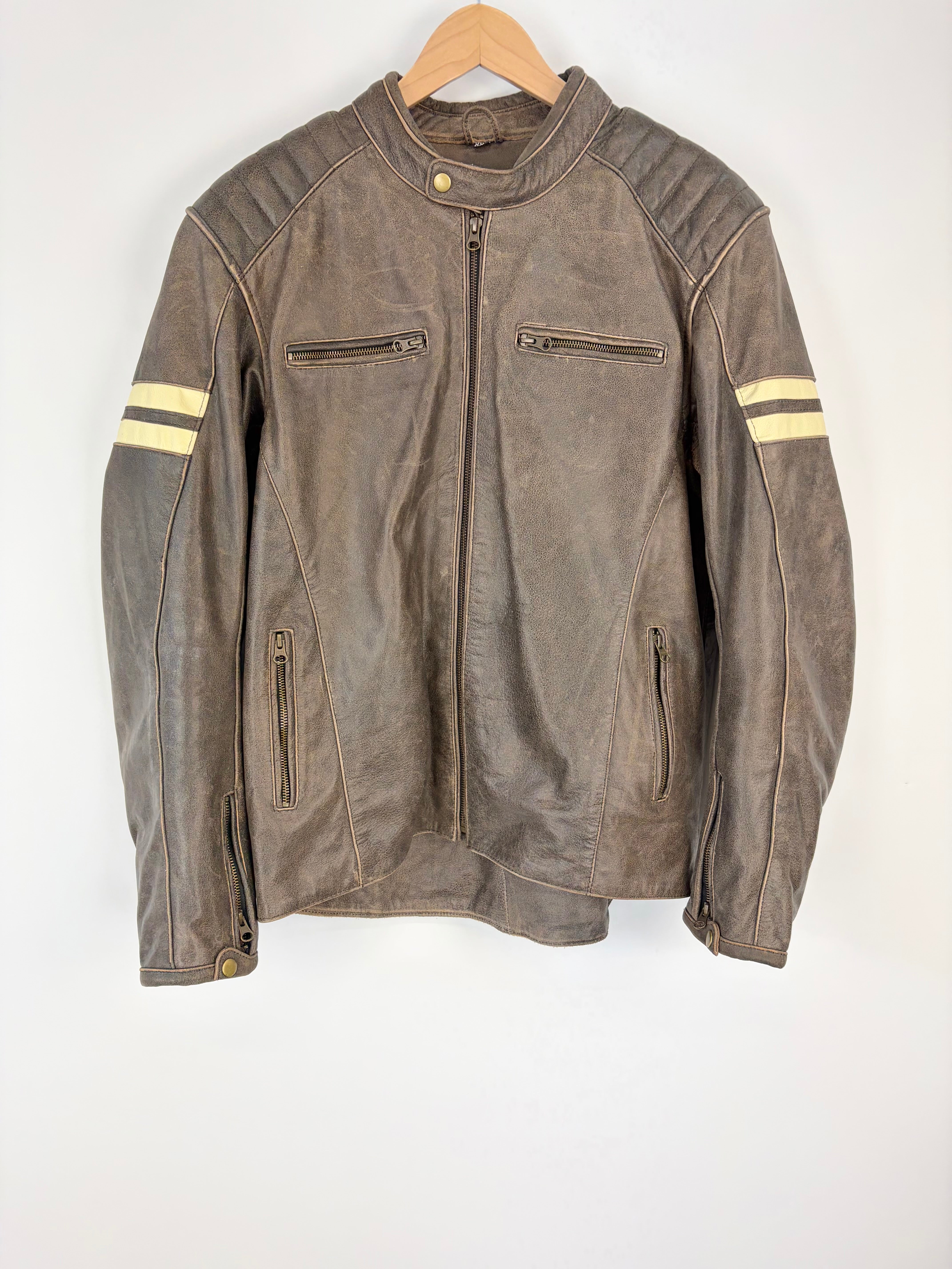 Brown leather jacket with yellow stripes on sleeves hanging on a wooden hanger against a white background