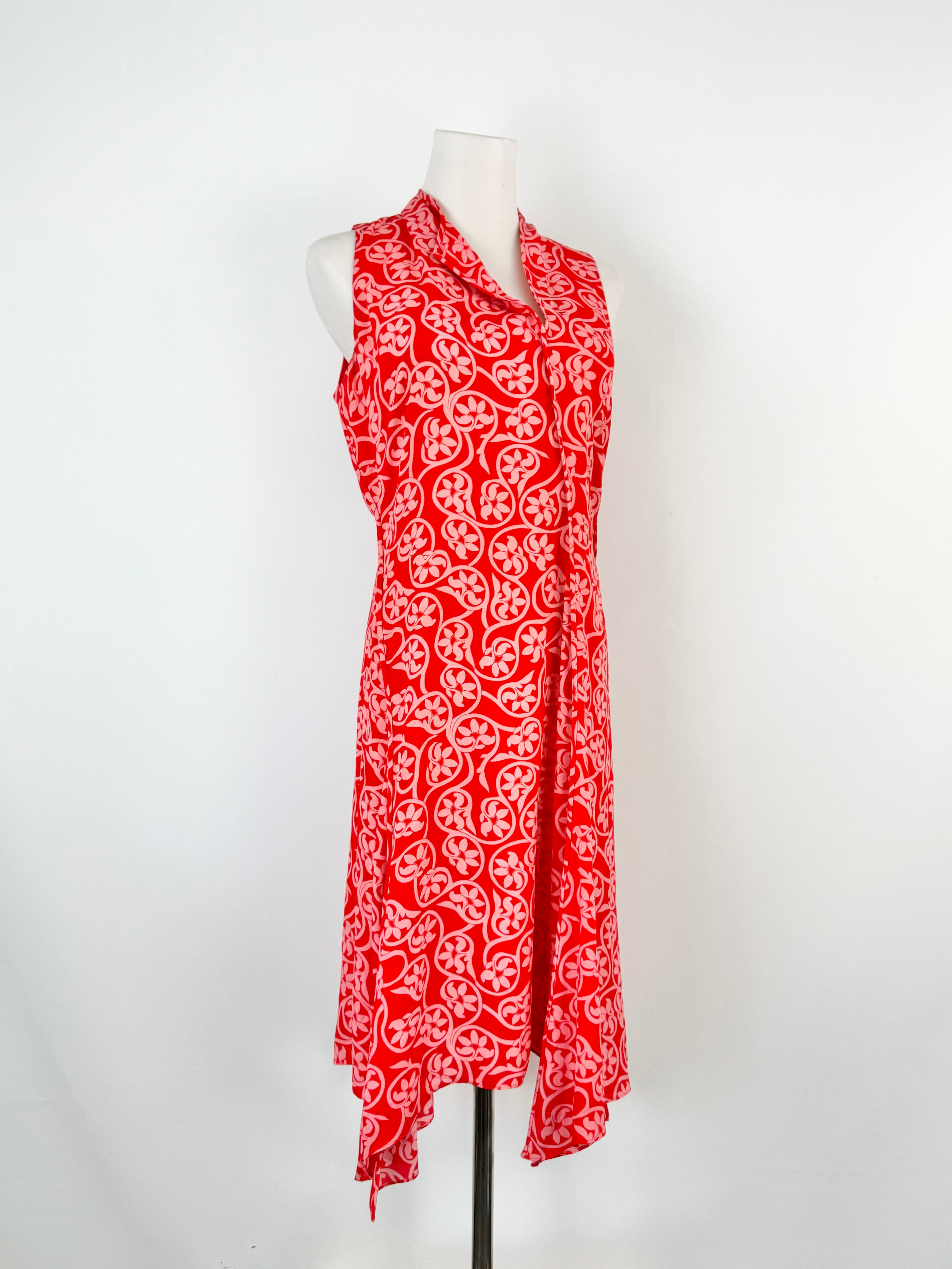 Red and white patterned dress on a mannequin against a white background