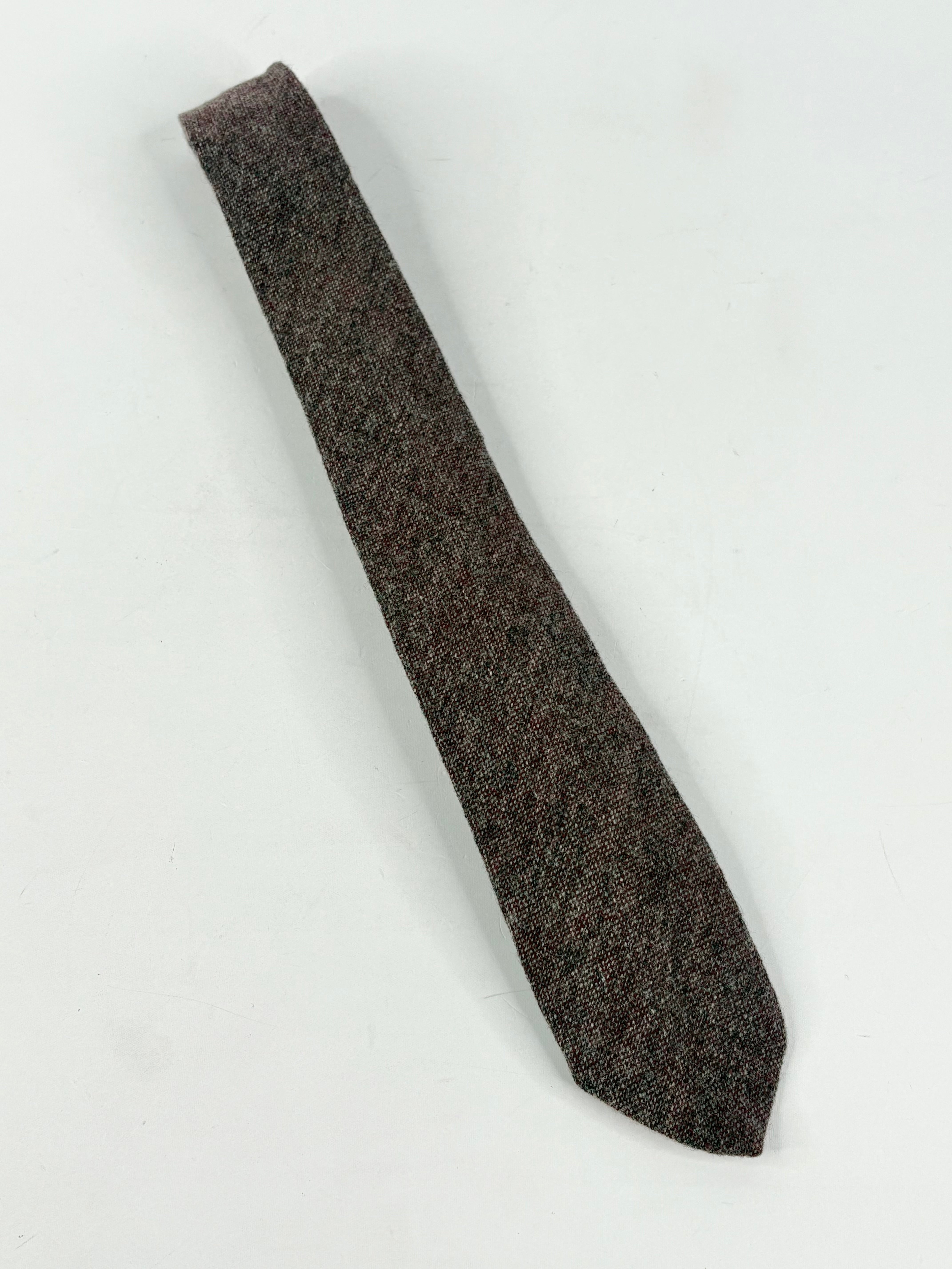 Dark red textured tie on a light gray background