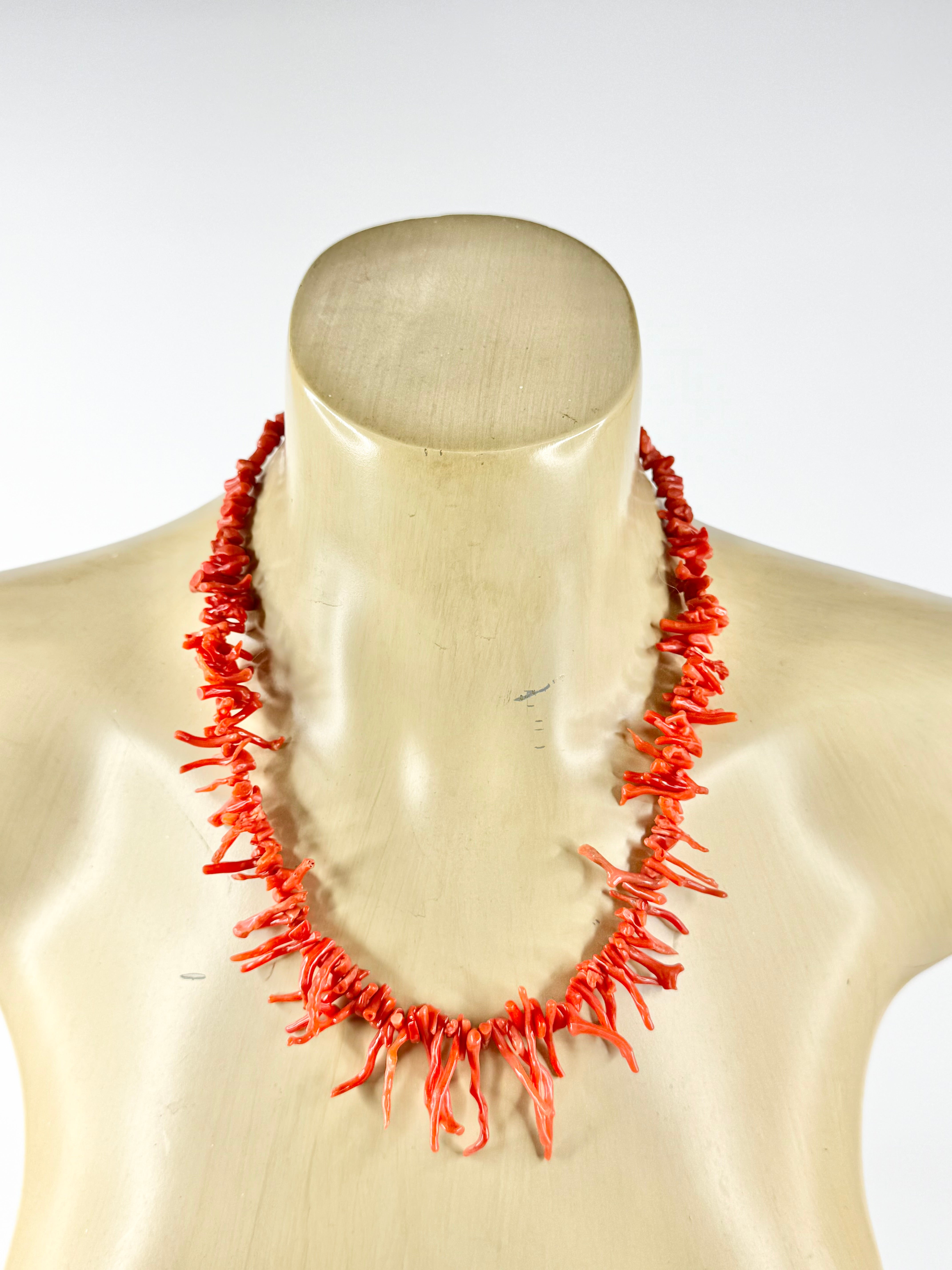 Coral necklace on a mannequin against a white background