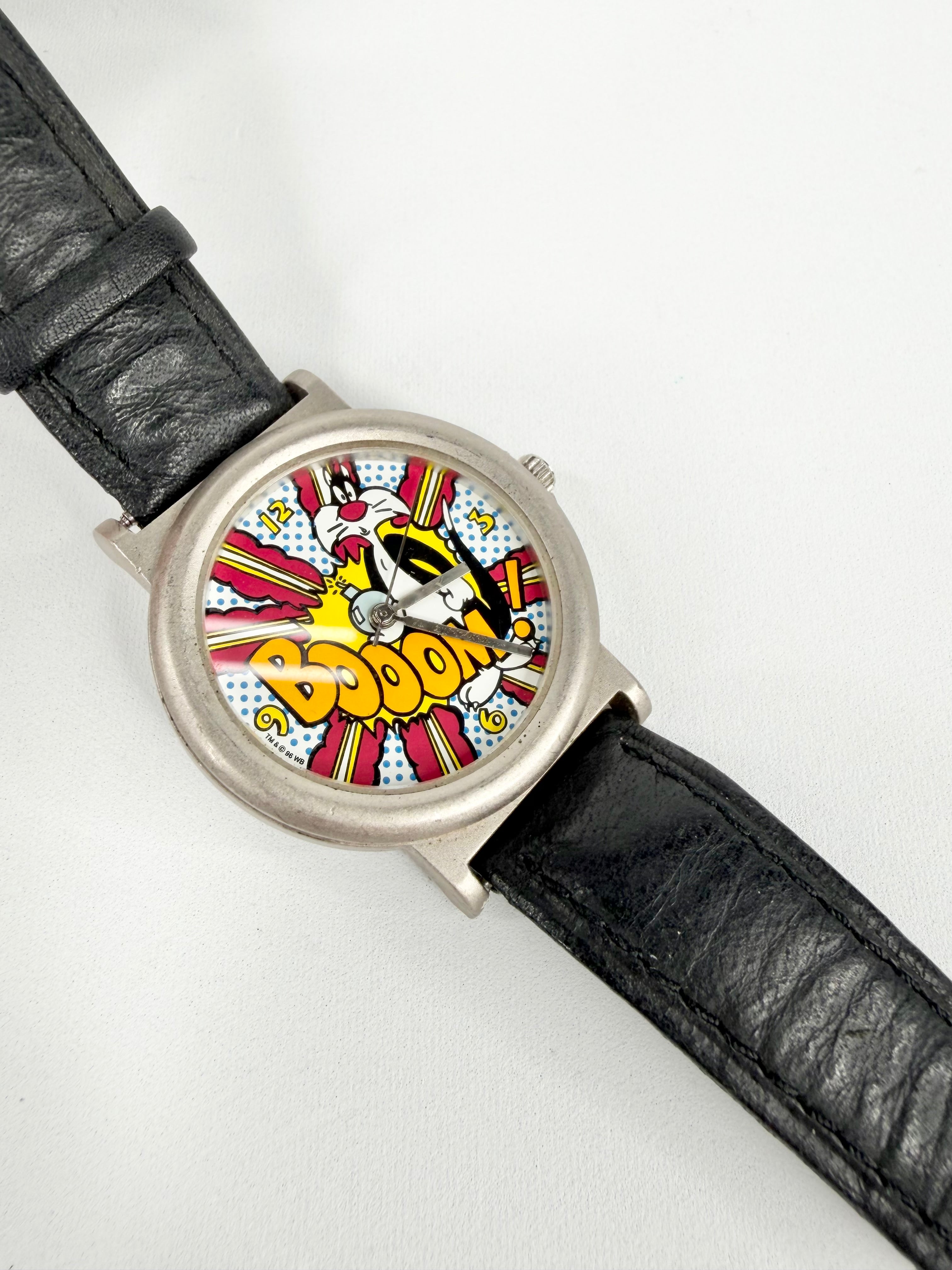 Watch with a colorful 'BOOM!' design on the dial against a white background