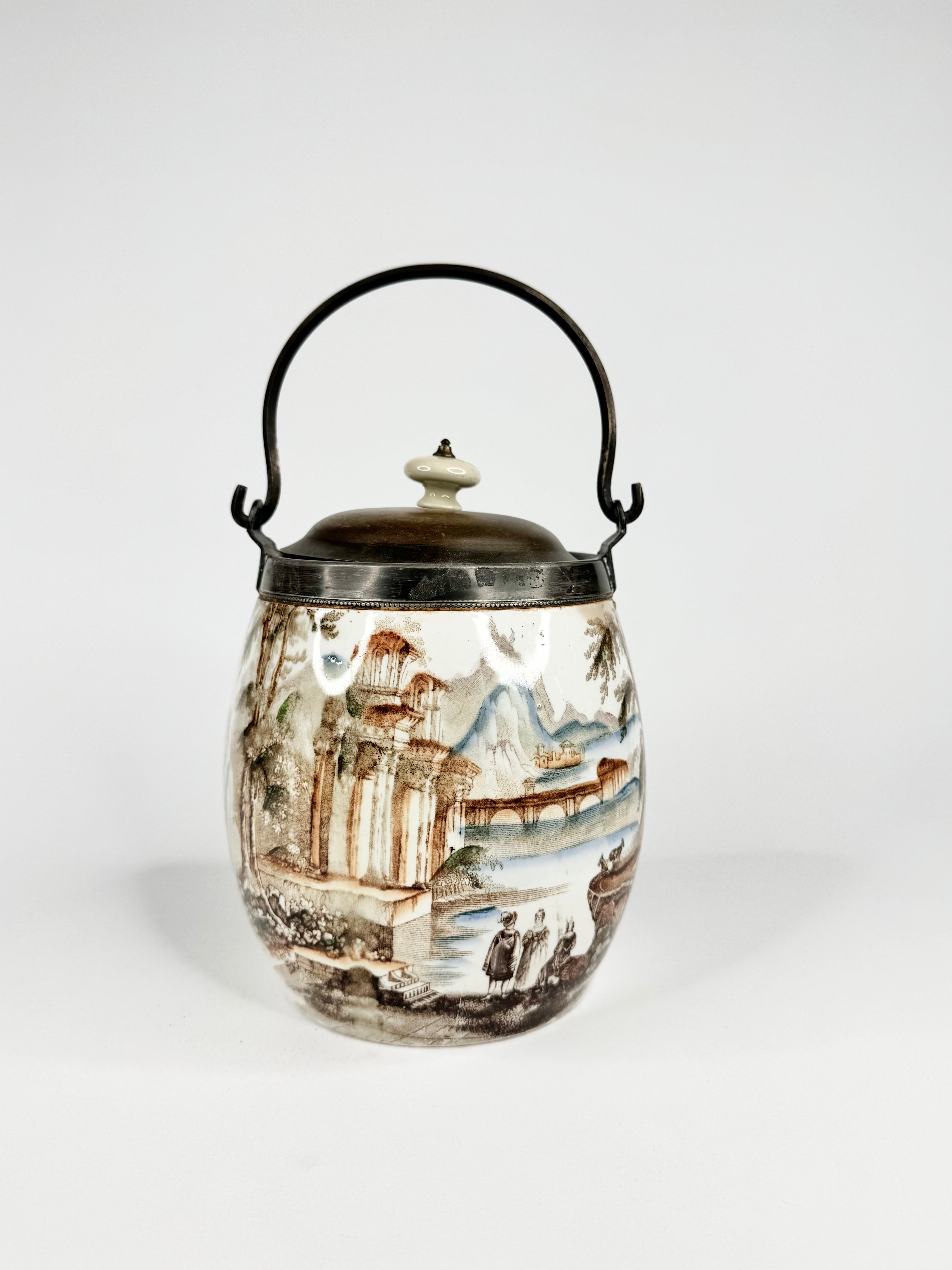 Decorative jar with a scenic design and black handle on a white background