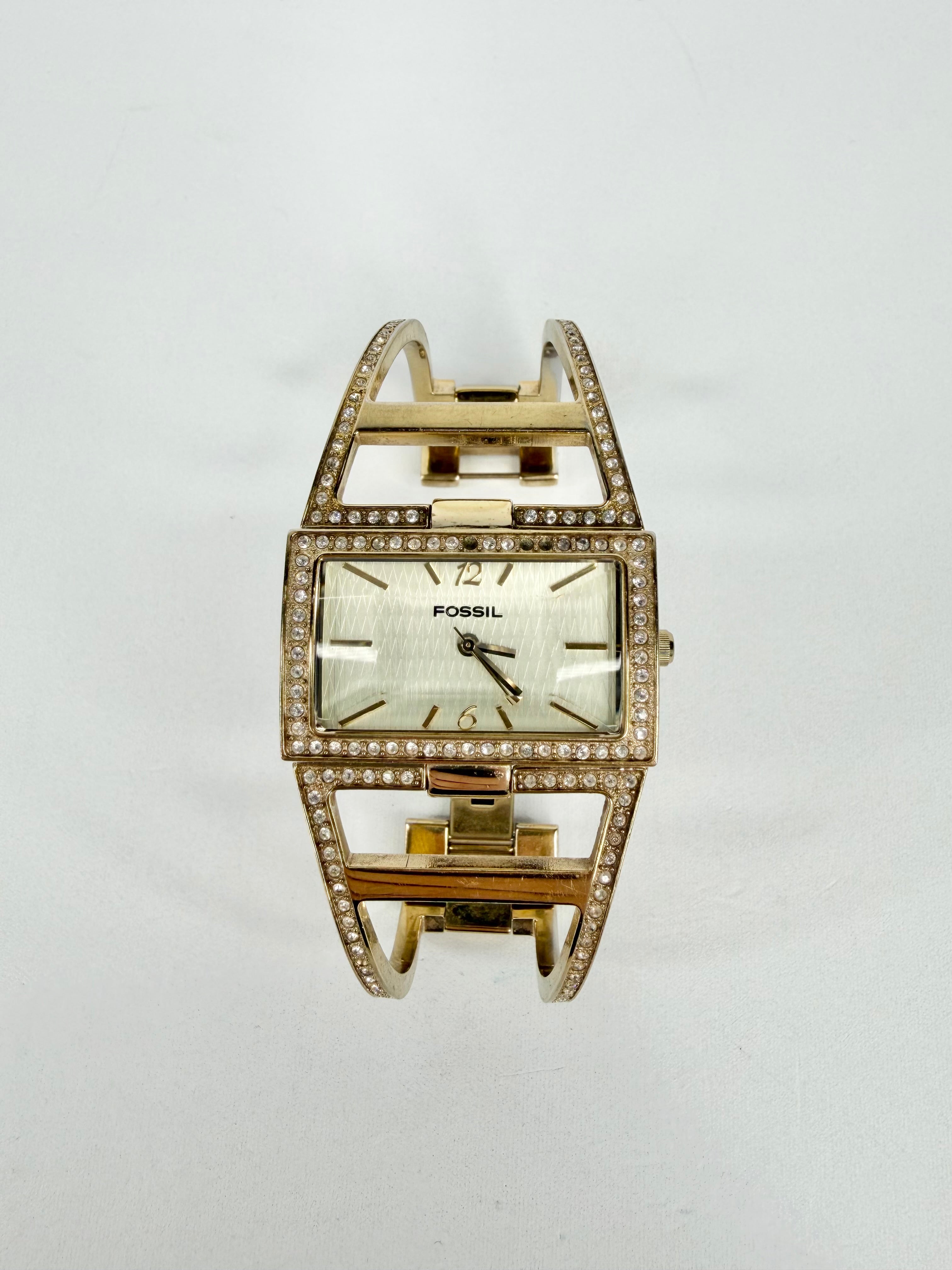 Gold Fossil watch with diamond accents on a white background
