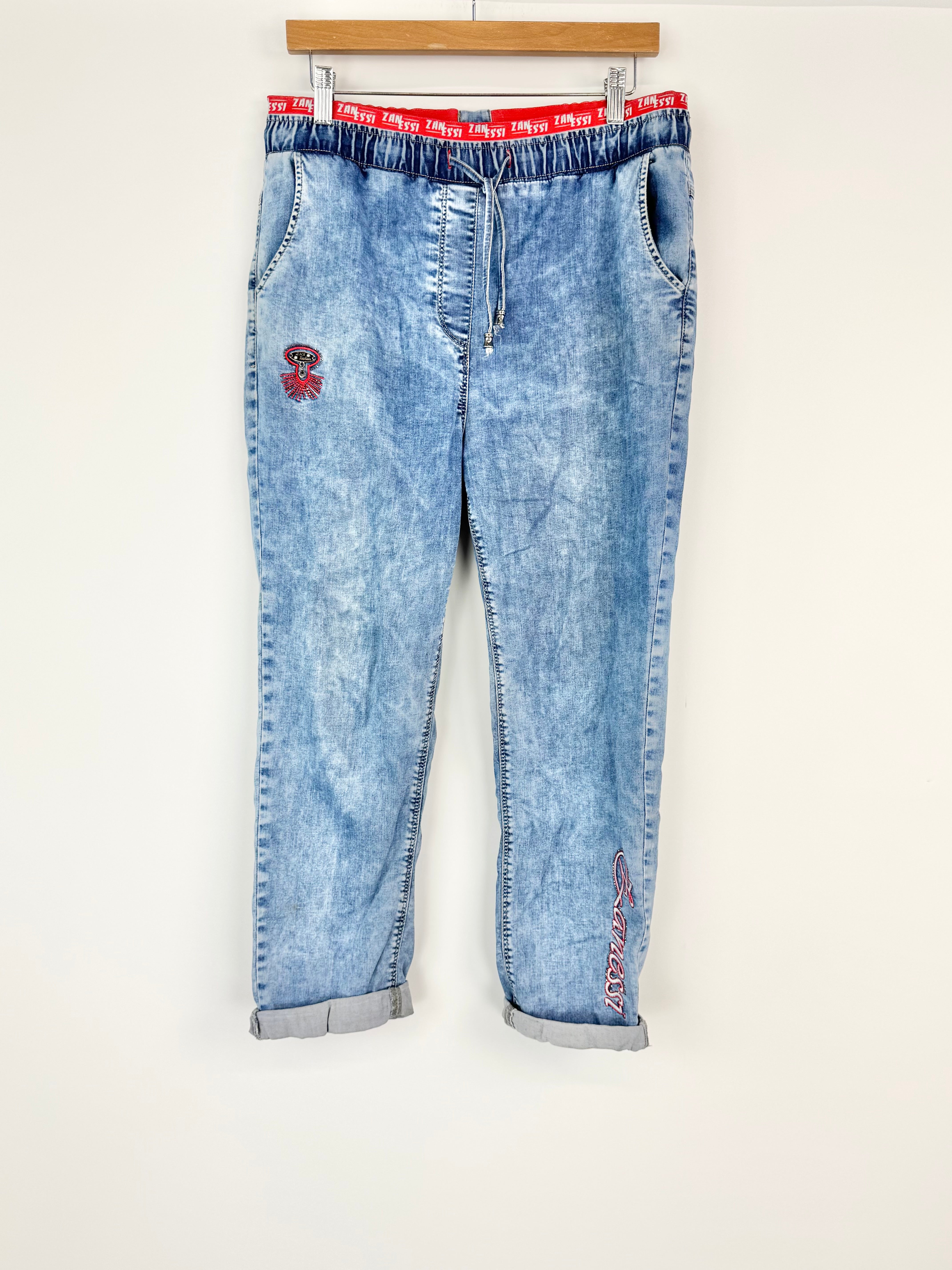 Light blue jeans with red waistband on a white background