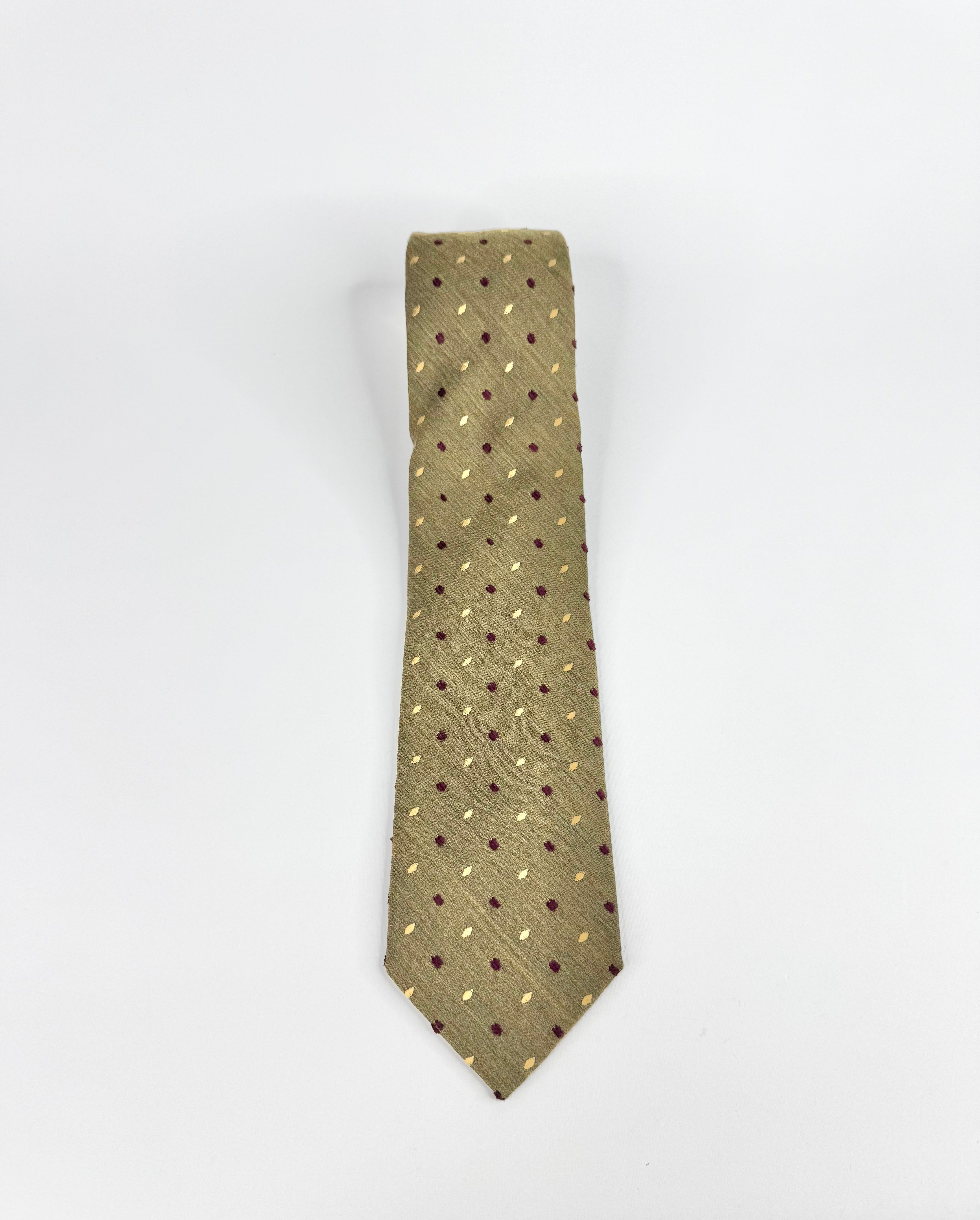 Green tie with small patterns on a white background