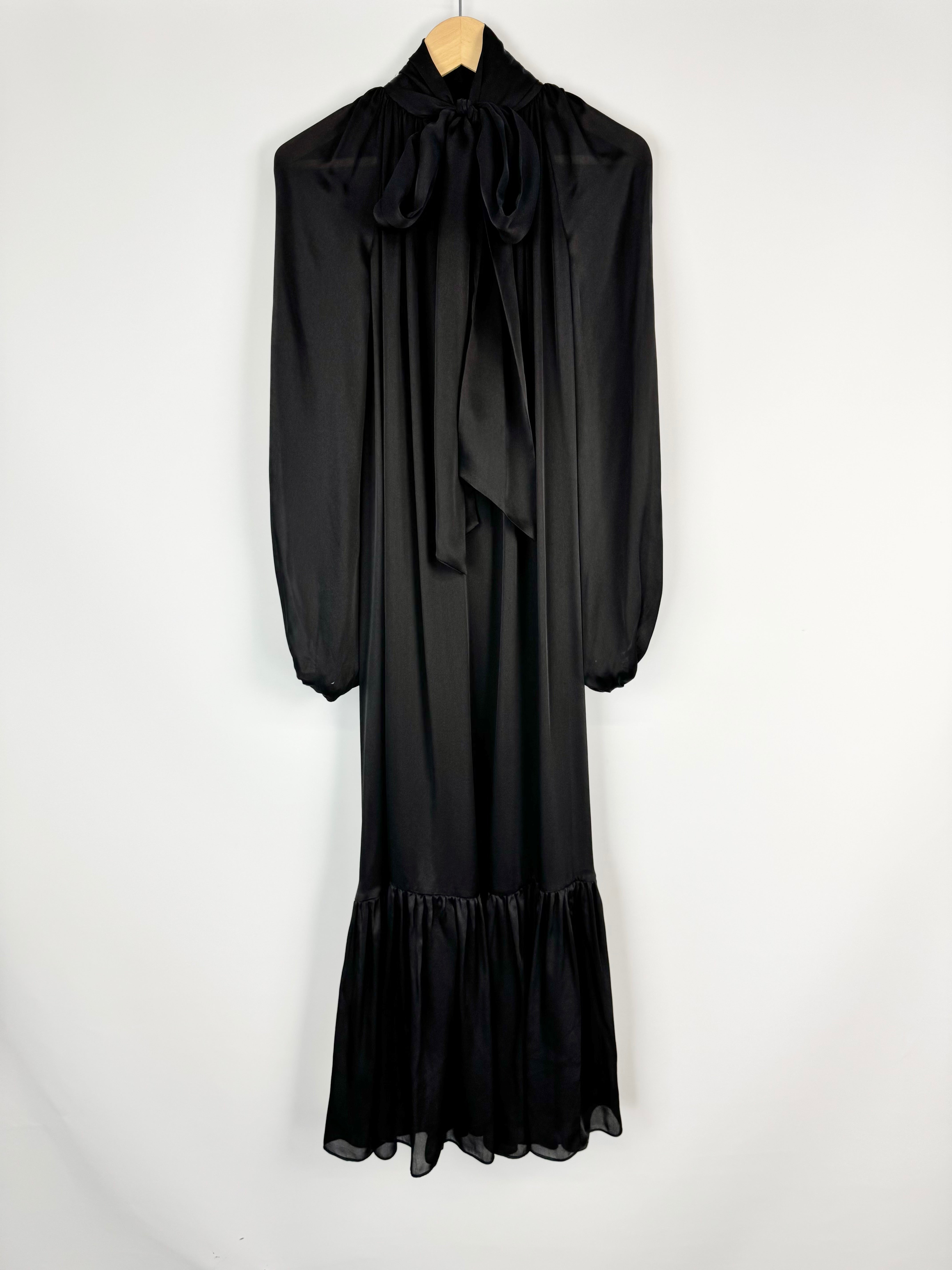 Black dress with long sleeves and a bow detail on a white background