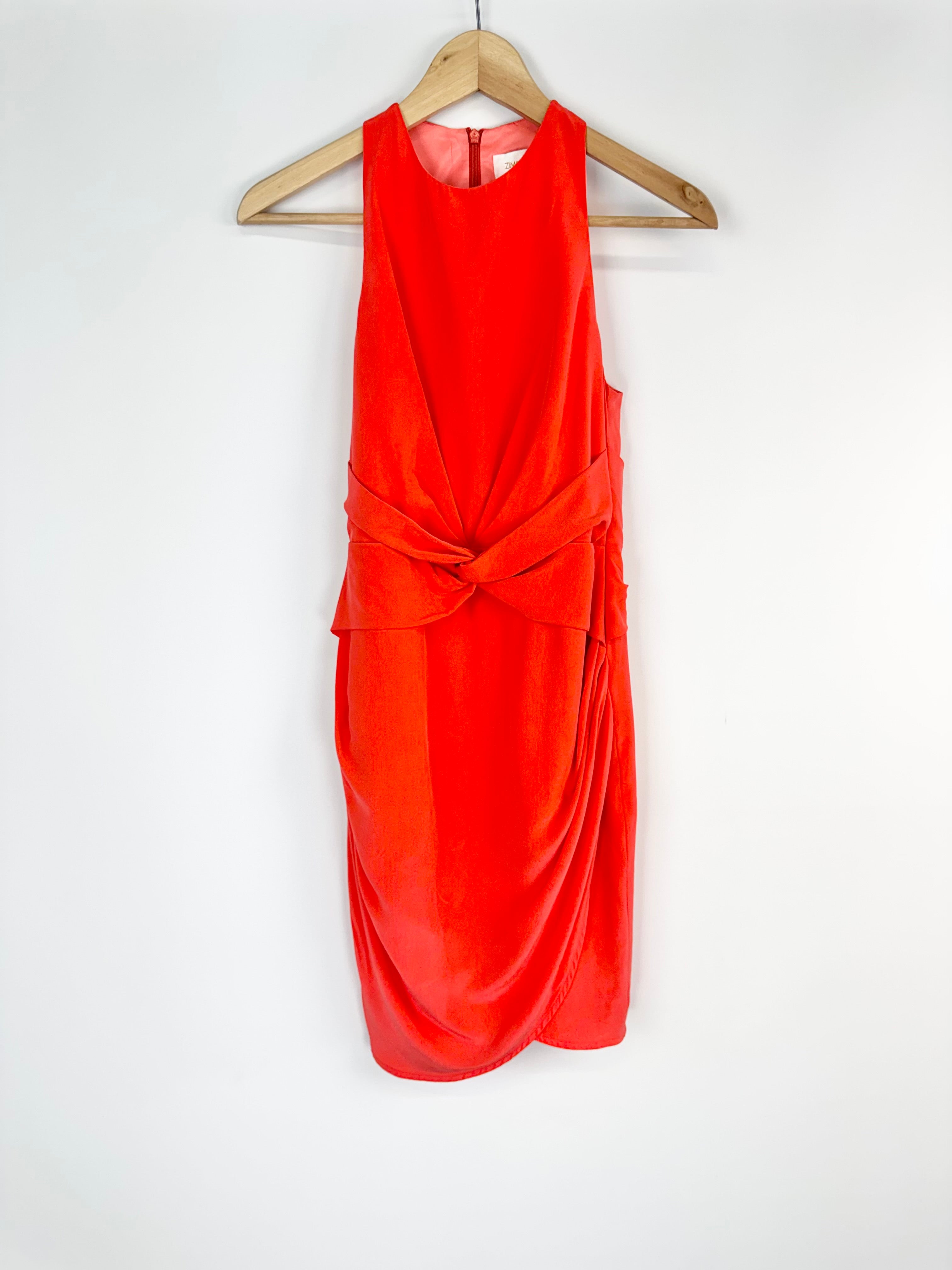 Orange dress on a hanger against a white background
