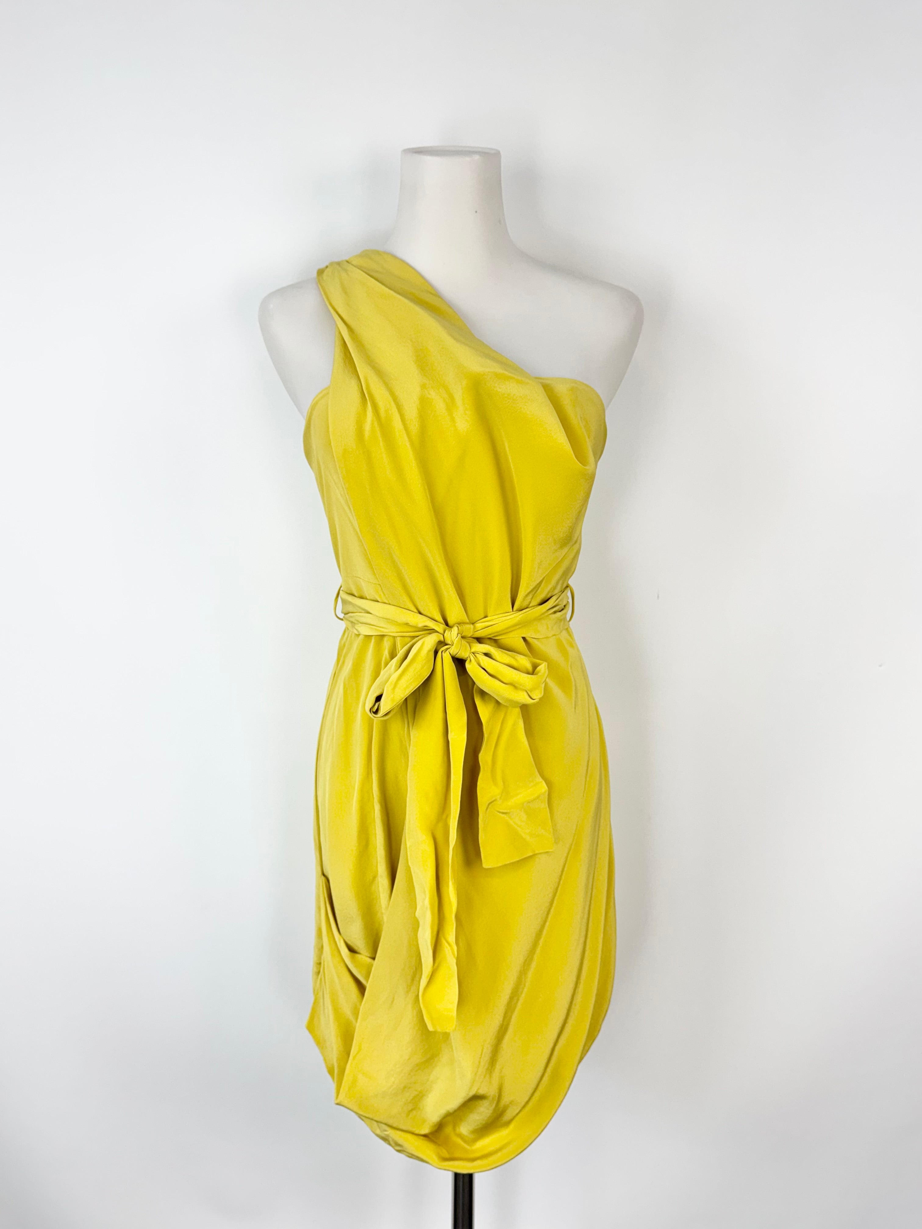 Yellow one-shoulder dress on a mannequin against a white background