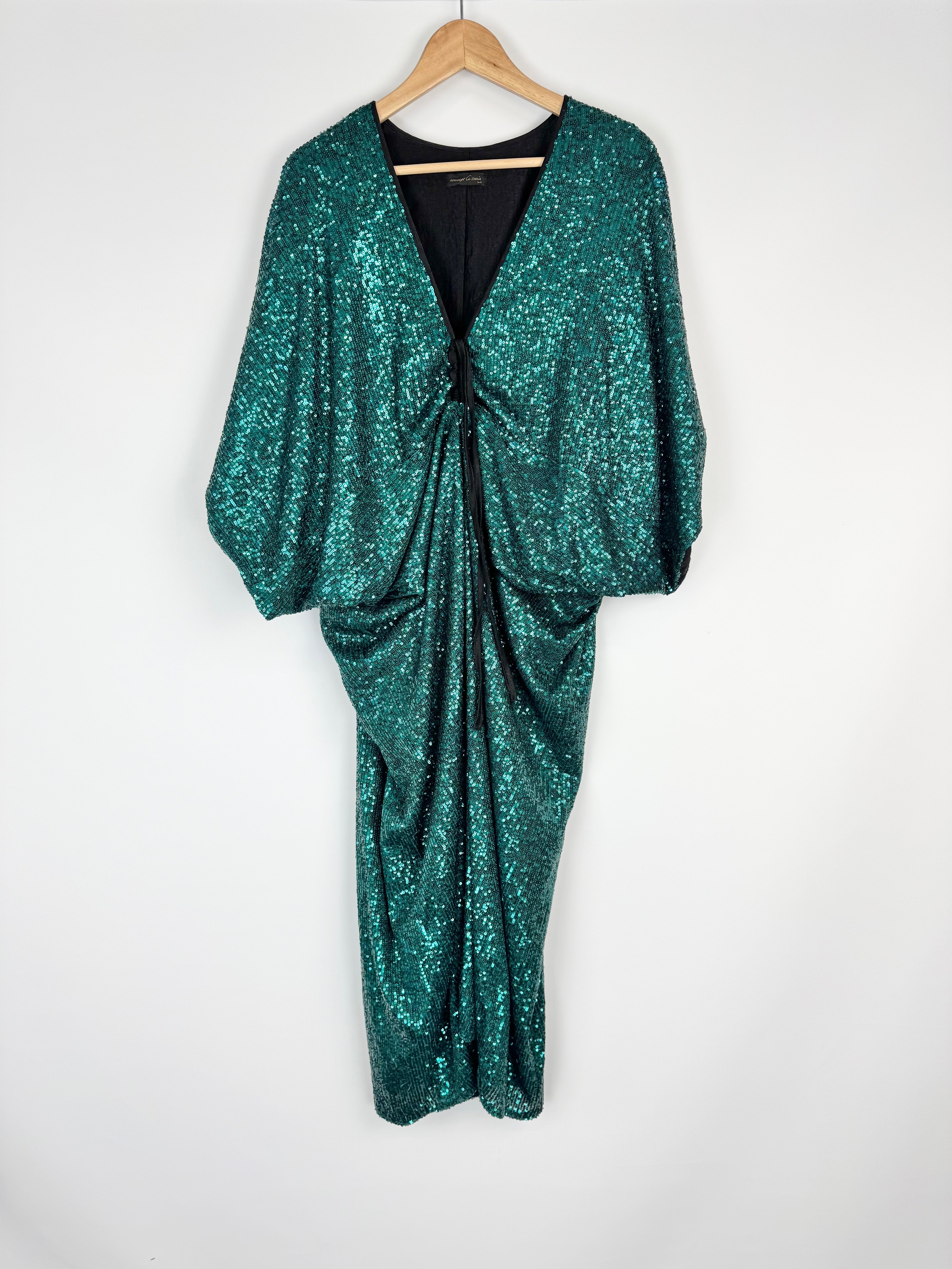Teal sequin dress on a hanger against a white background