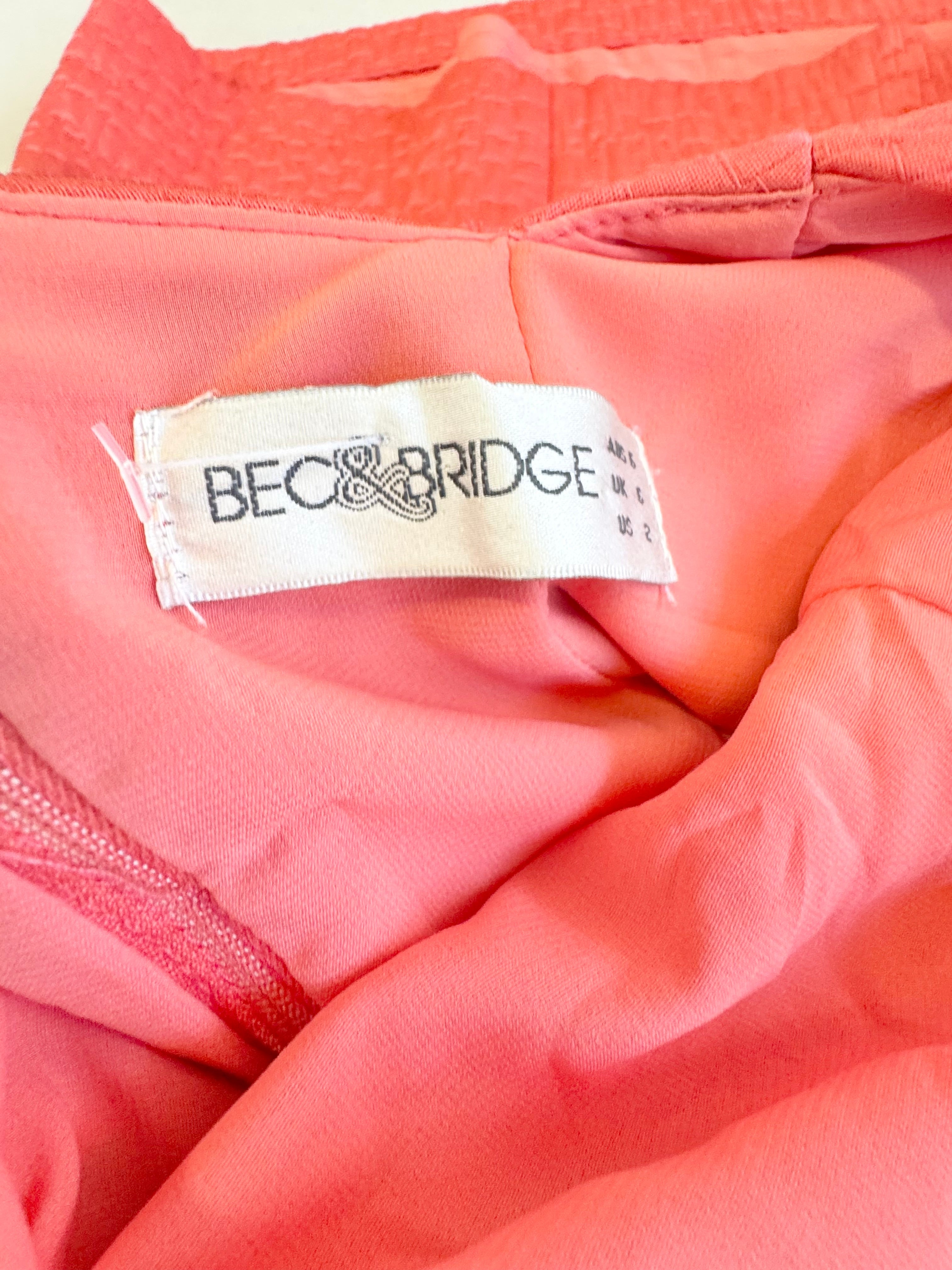 Close-up of a pink garment with a visible label featuring the brand 'Bec & Bridge'.