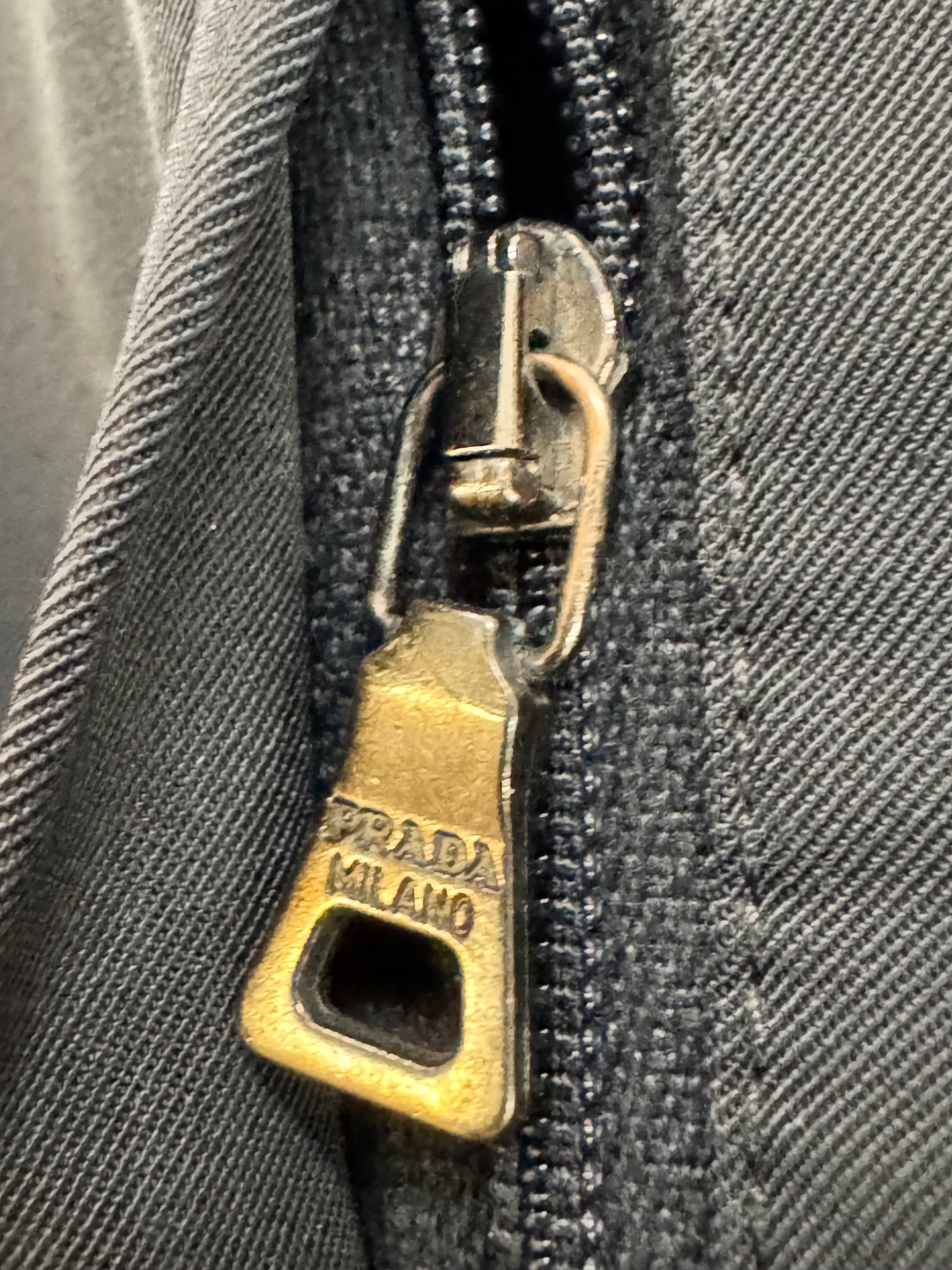 Close-up of a Prada zipper on a textured surface