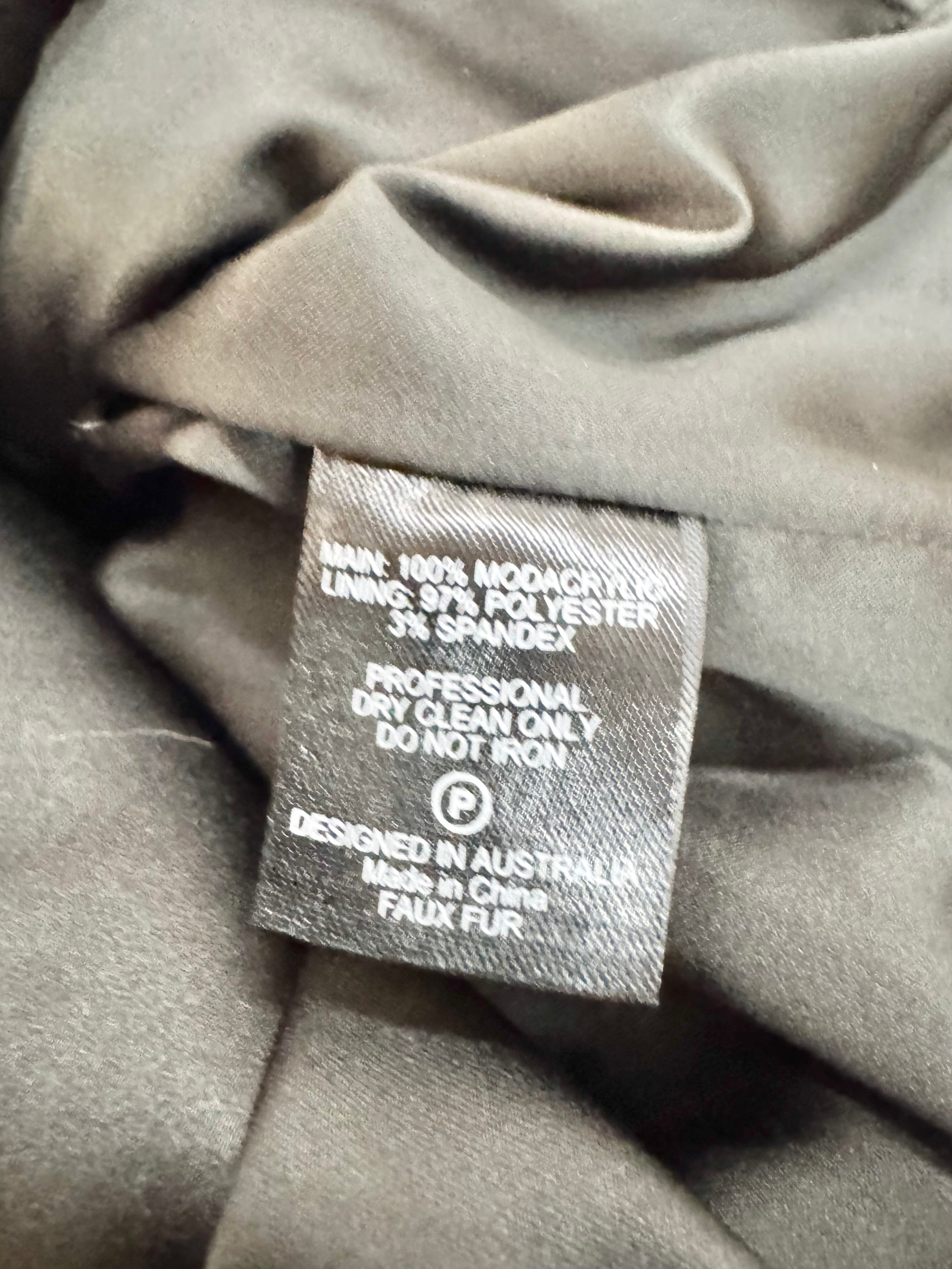 Fabric tag on a gray fabric background with text and branding.