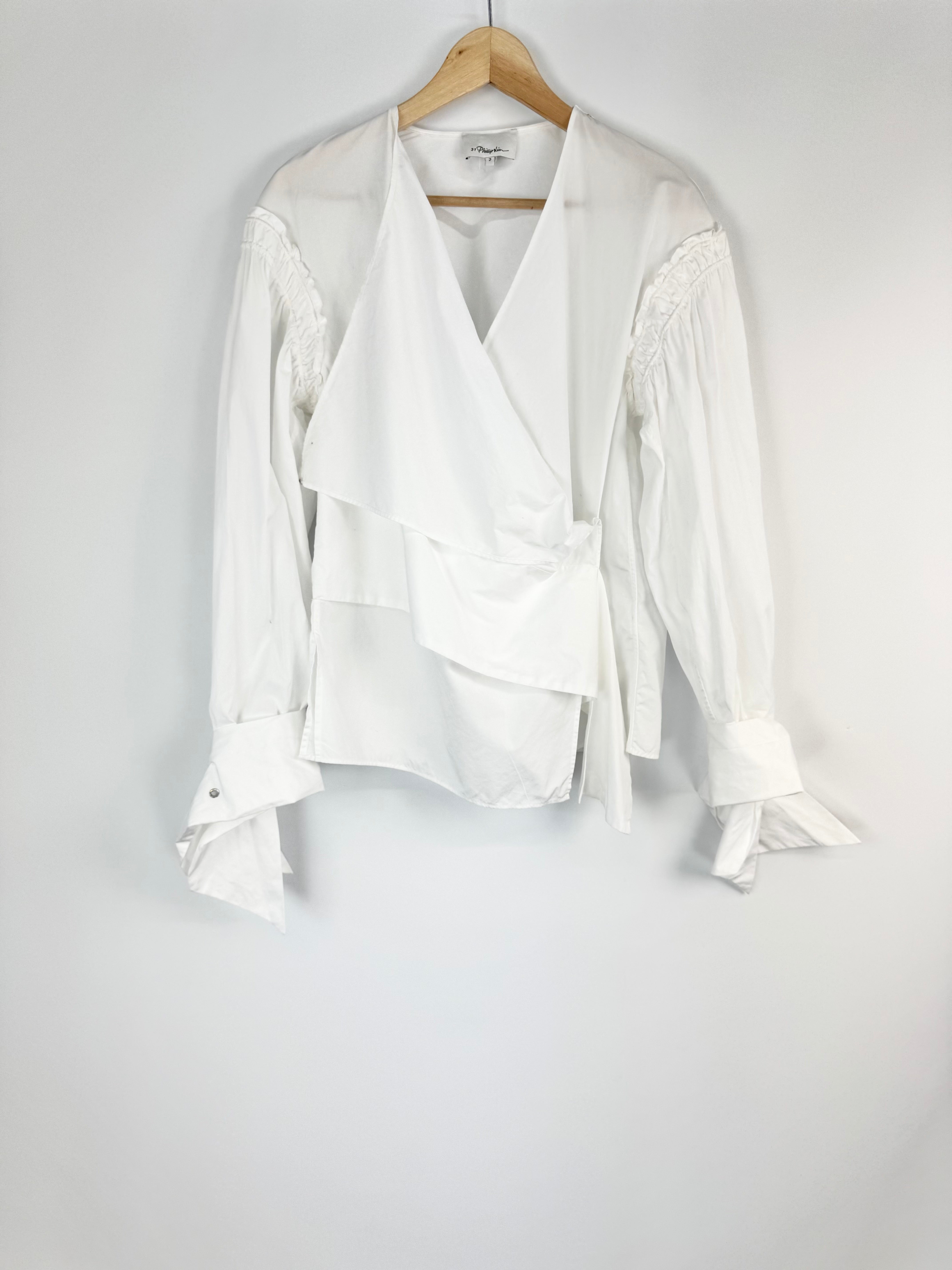 White blouse on a hanger against a white background