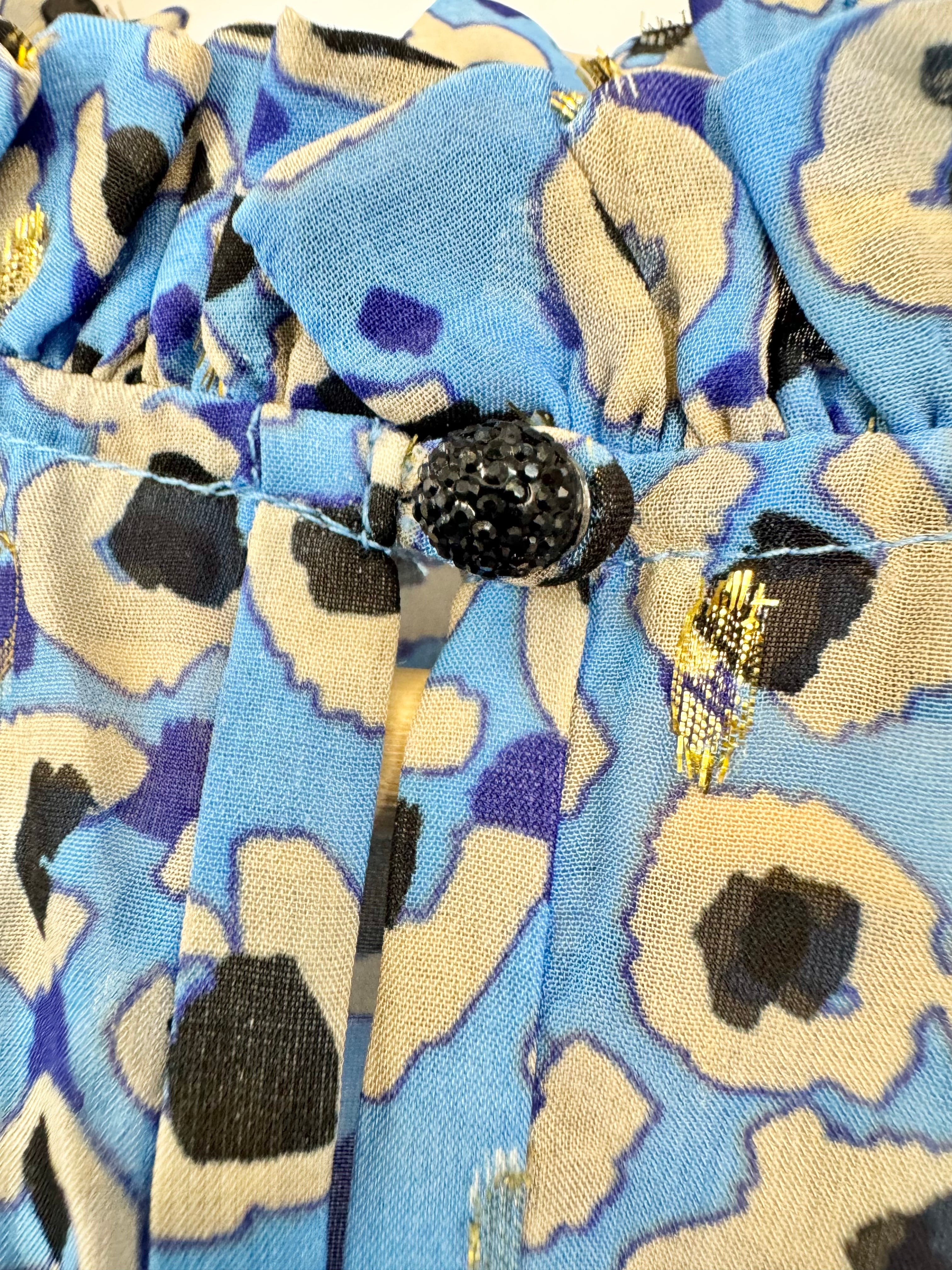 Close-up of a fabric with blue and beige pattern and black button