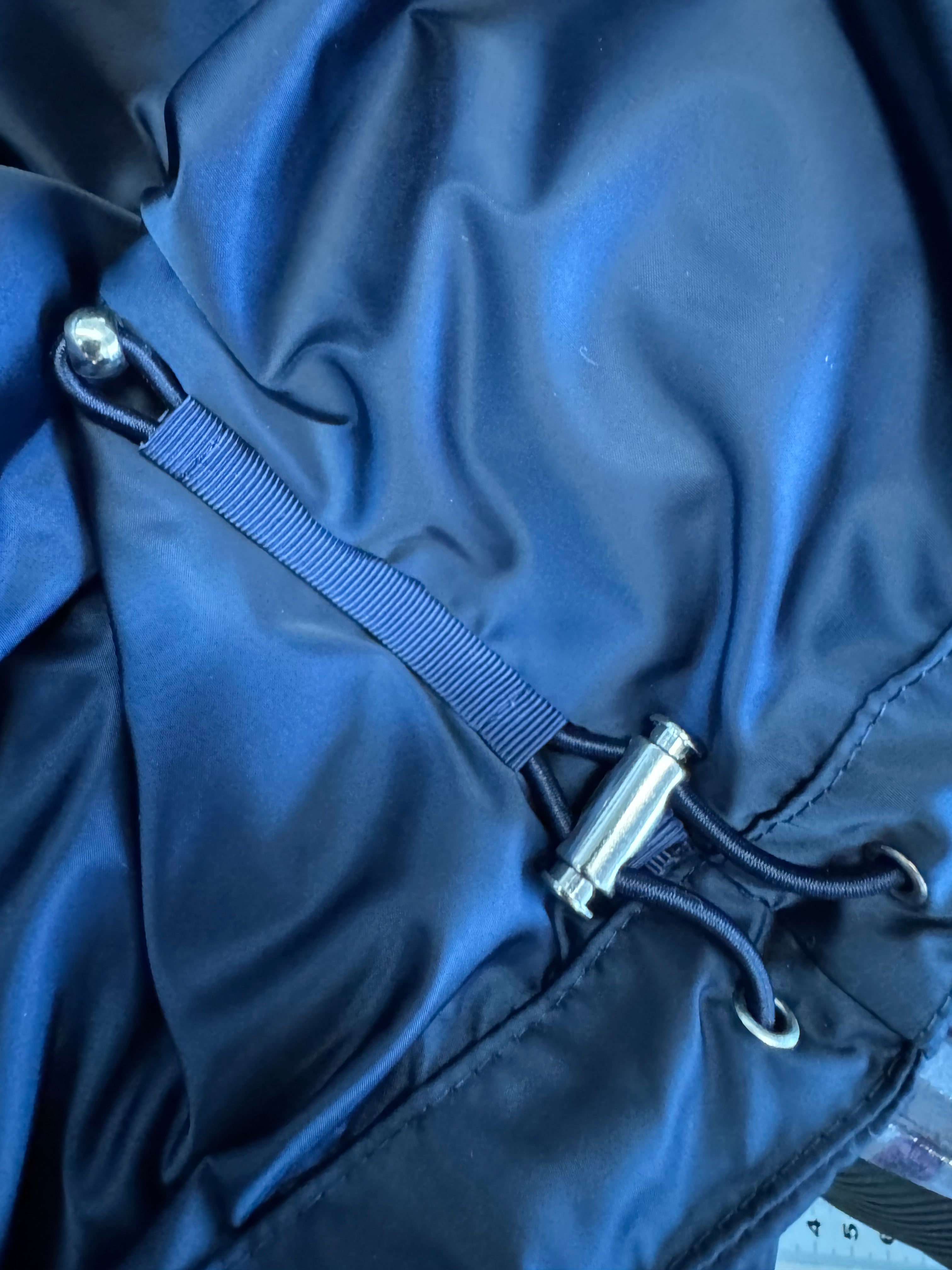 Close-up of a blue drawstring bag with metal eyelets.
