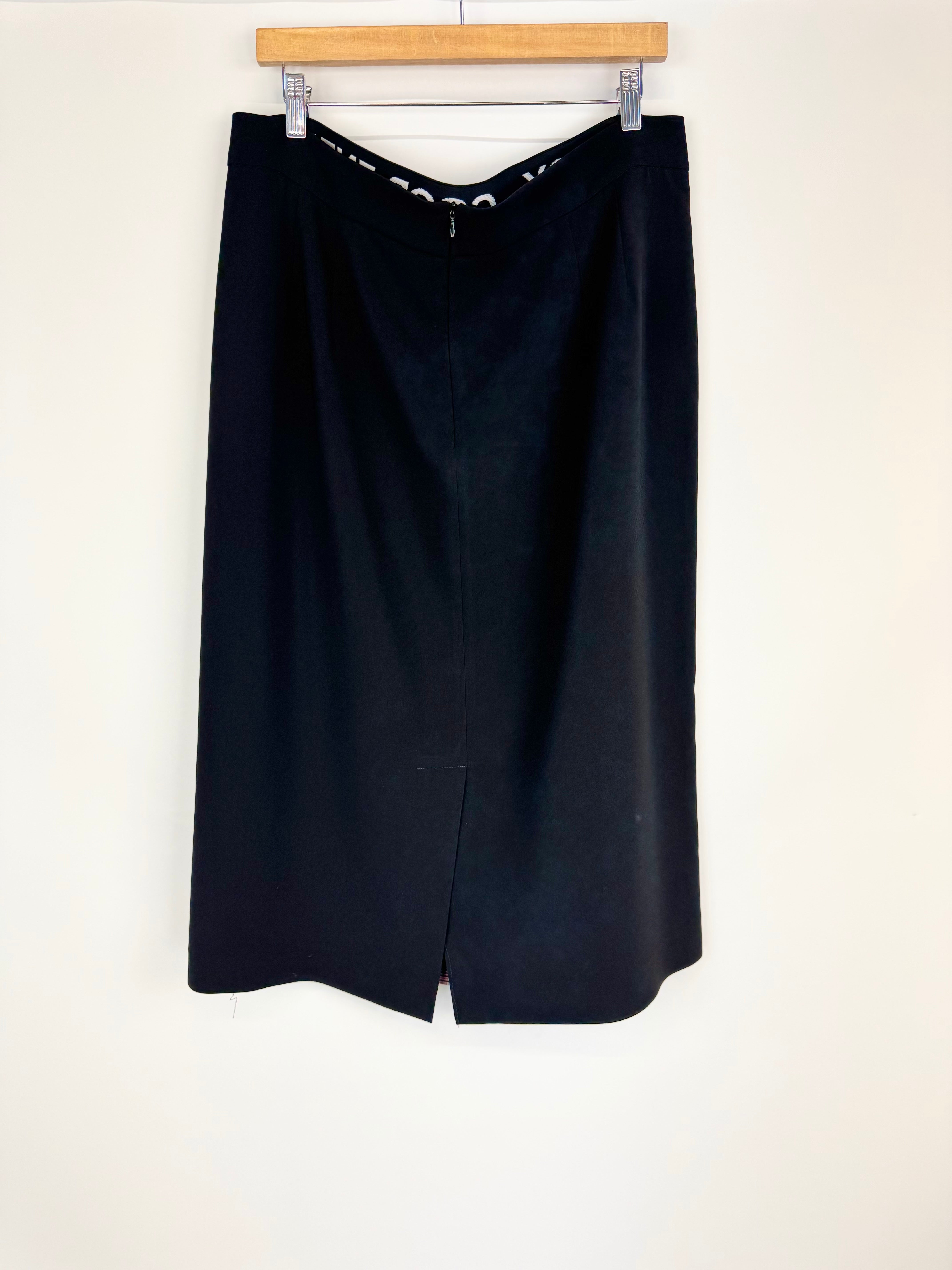 Black skirt on a hanger against a white background