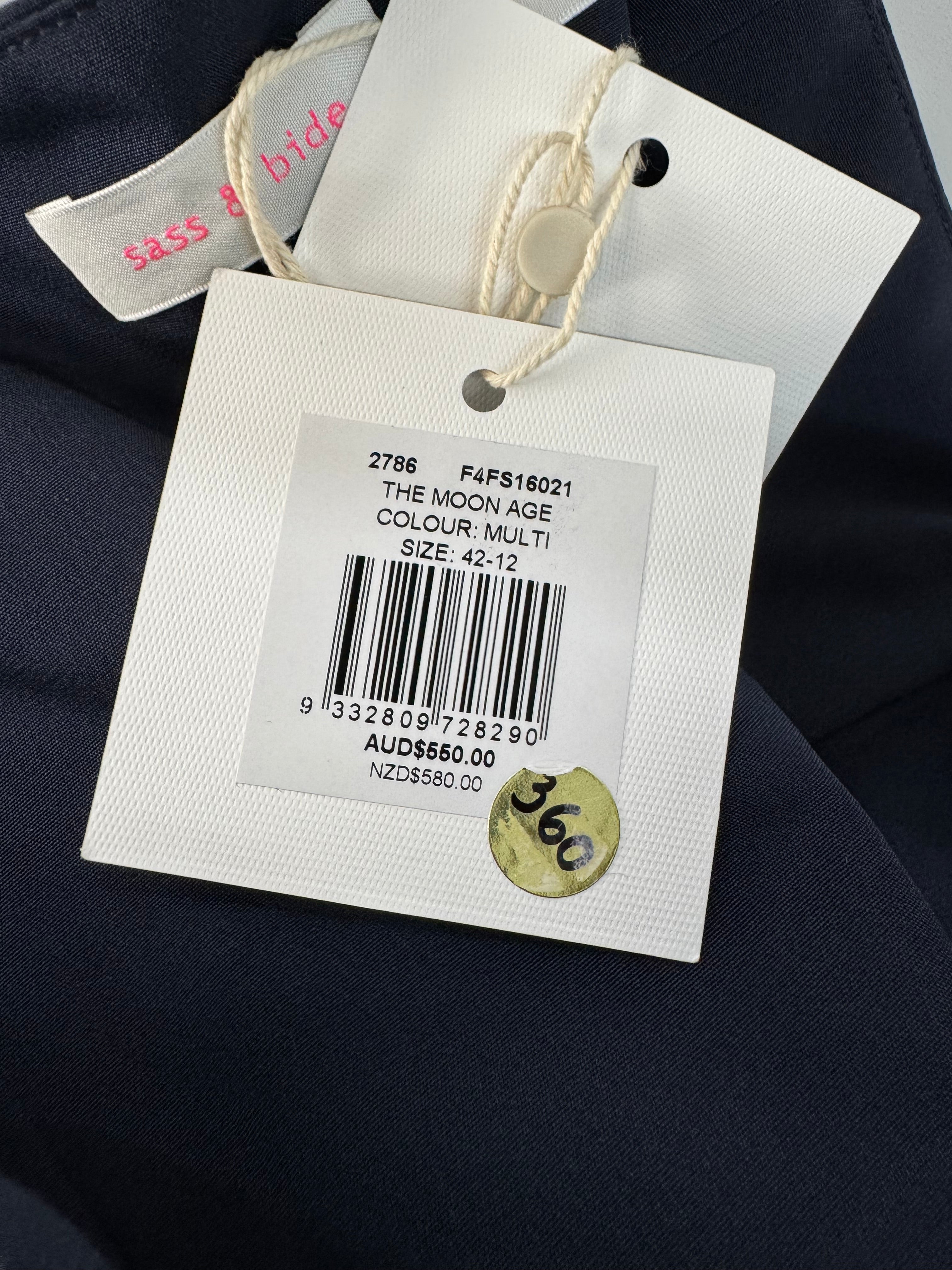 Clothing tag with barcode and product information on a dark fabric background