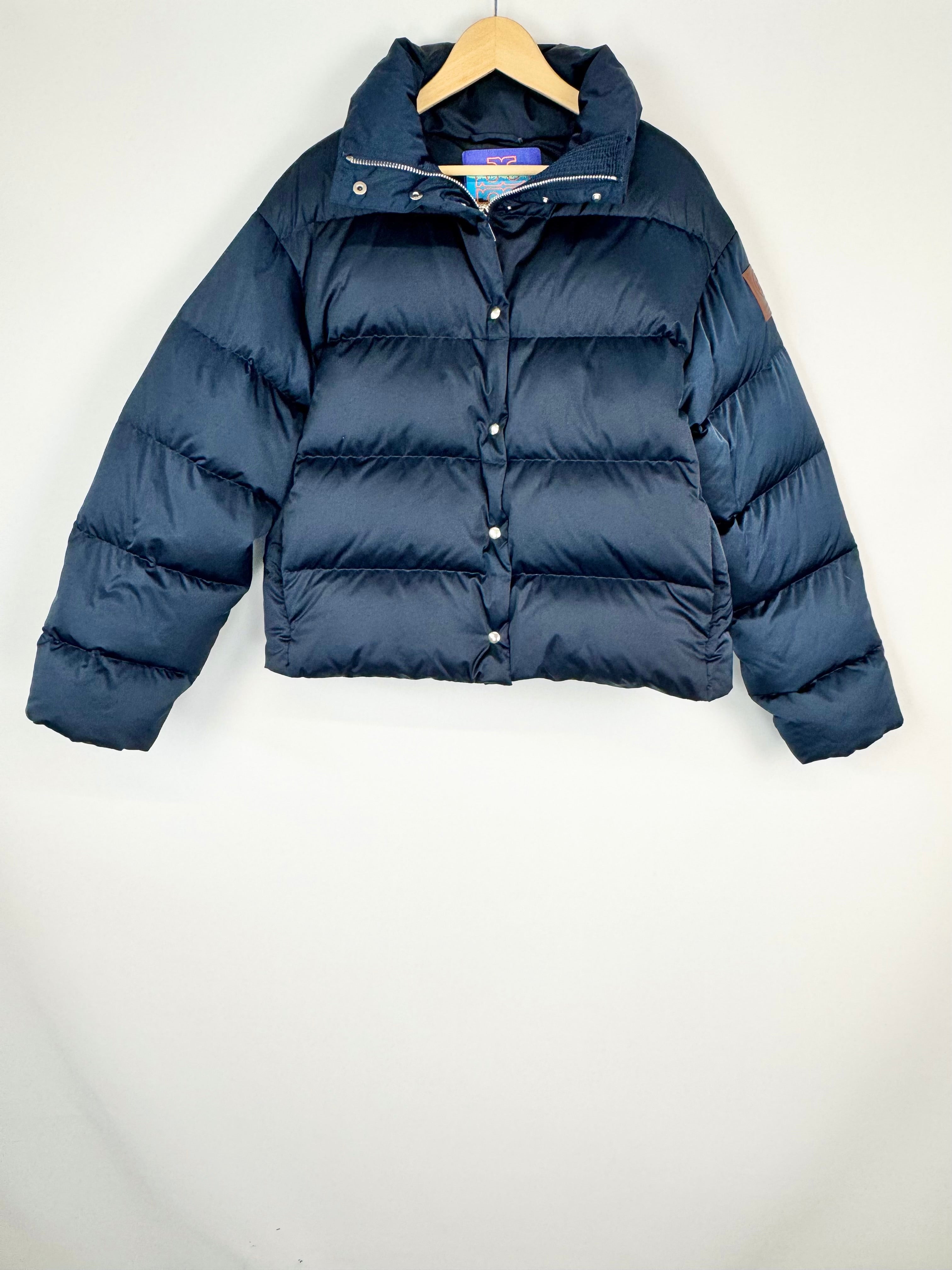 Navy blue puffer jacket on a wooden hanger against a white background