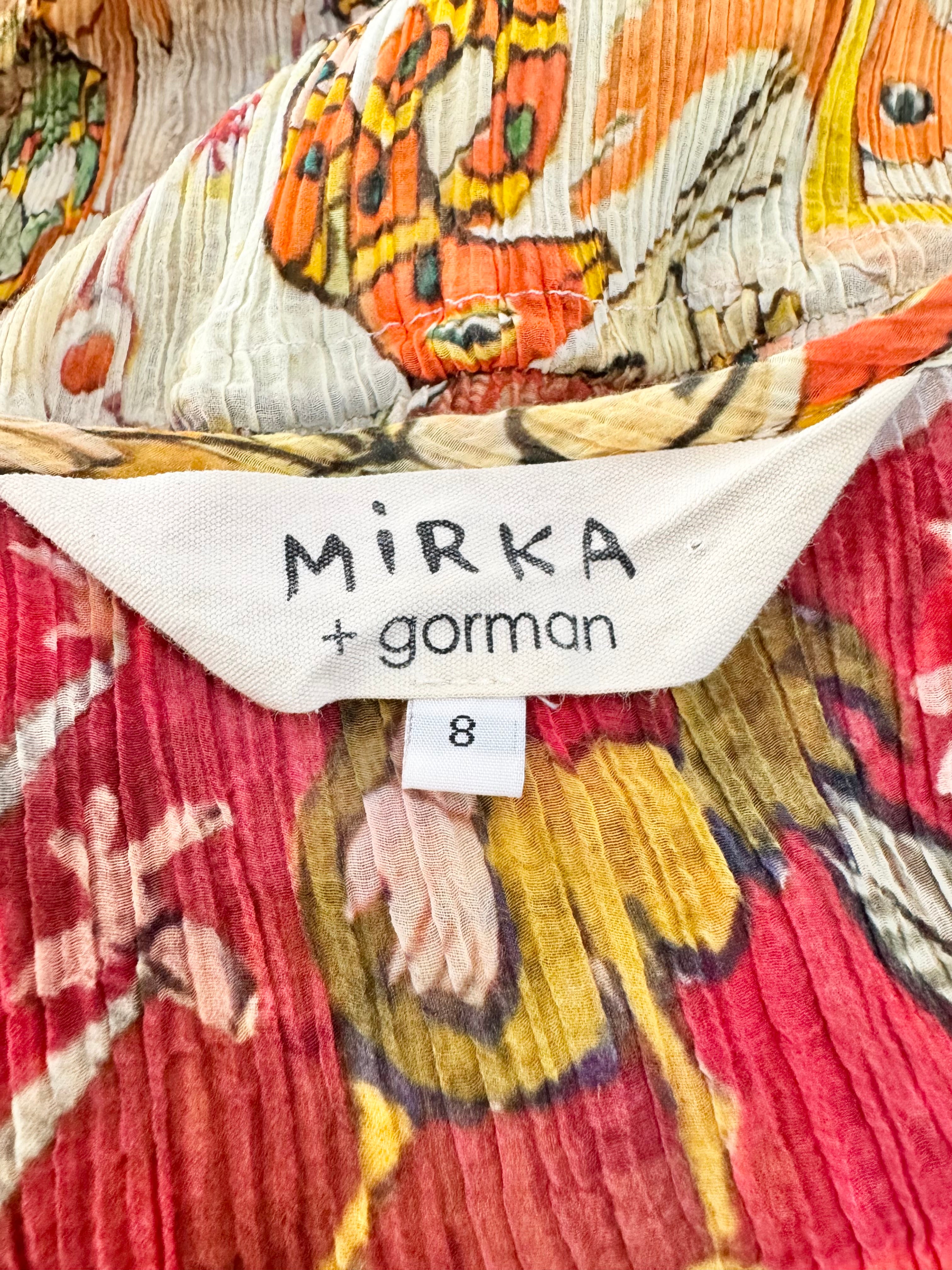 Close-up of a patterned fabric with 'Mirka + gorman' label and size tag.