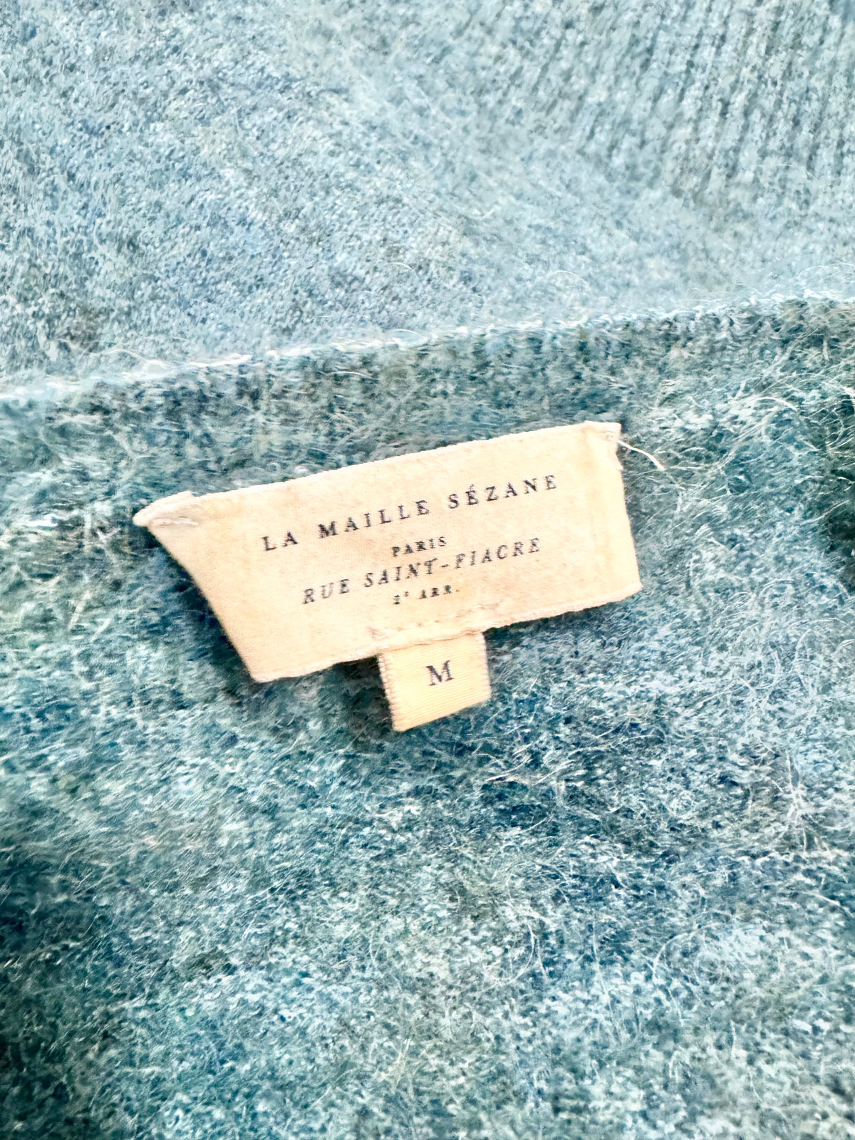 Close-up of a brand label on a textured fabric background