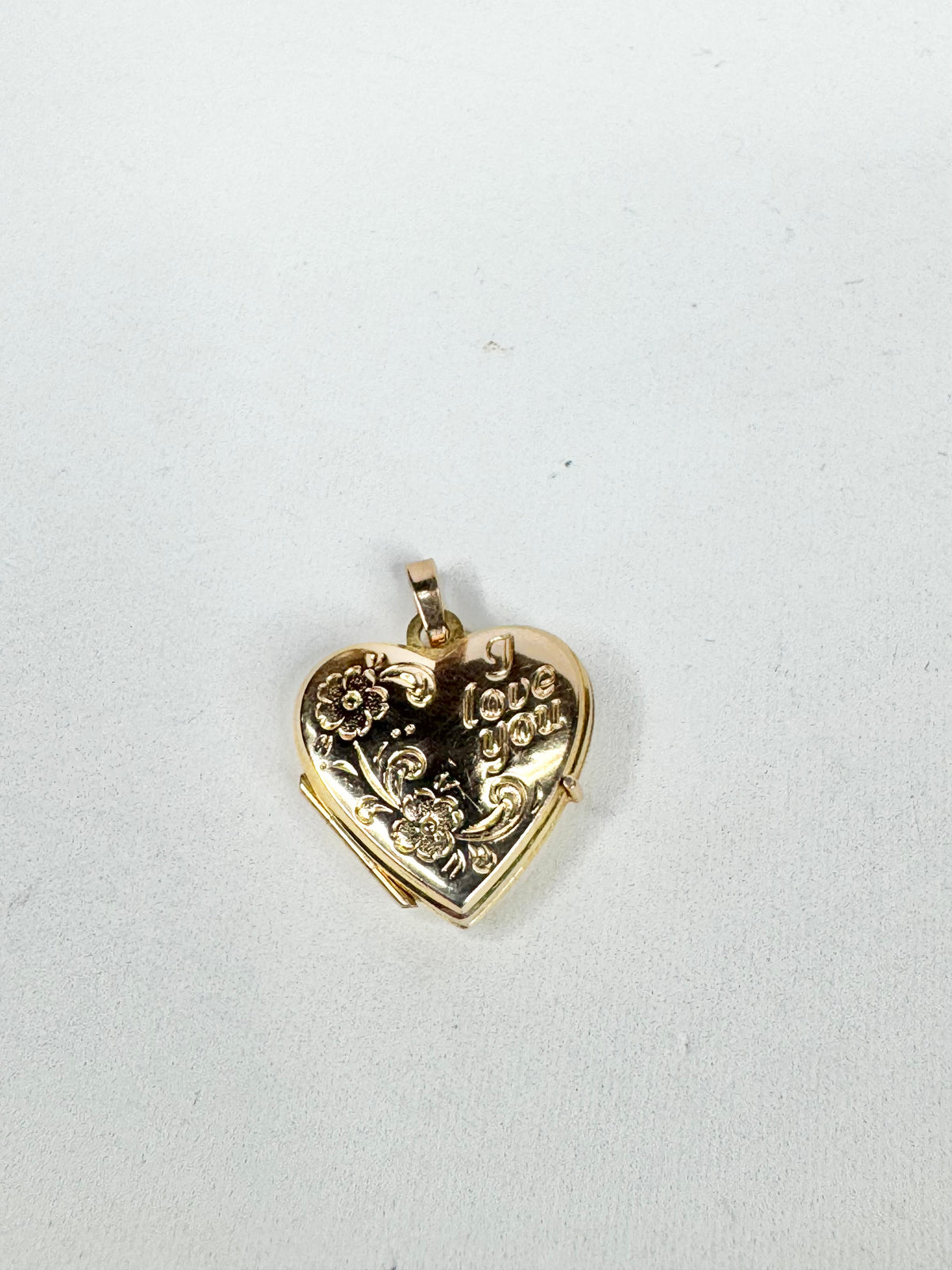 Gold heart-shaped locket on a white background
