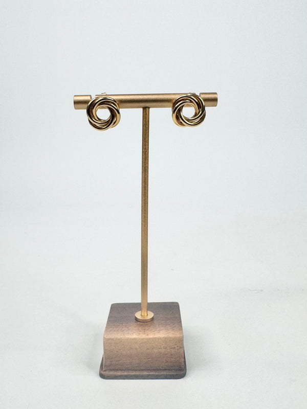 Gold earring stand with a square base on a white background