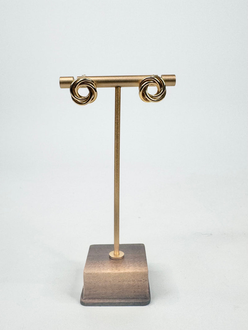Gold earring stand with a square base on a white background