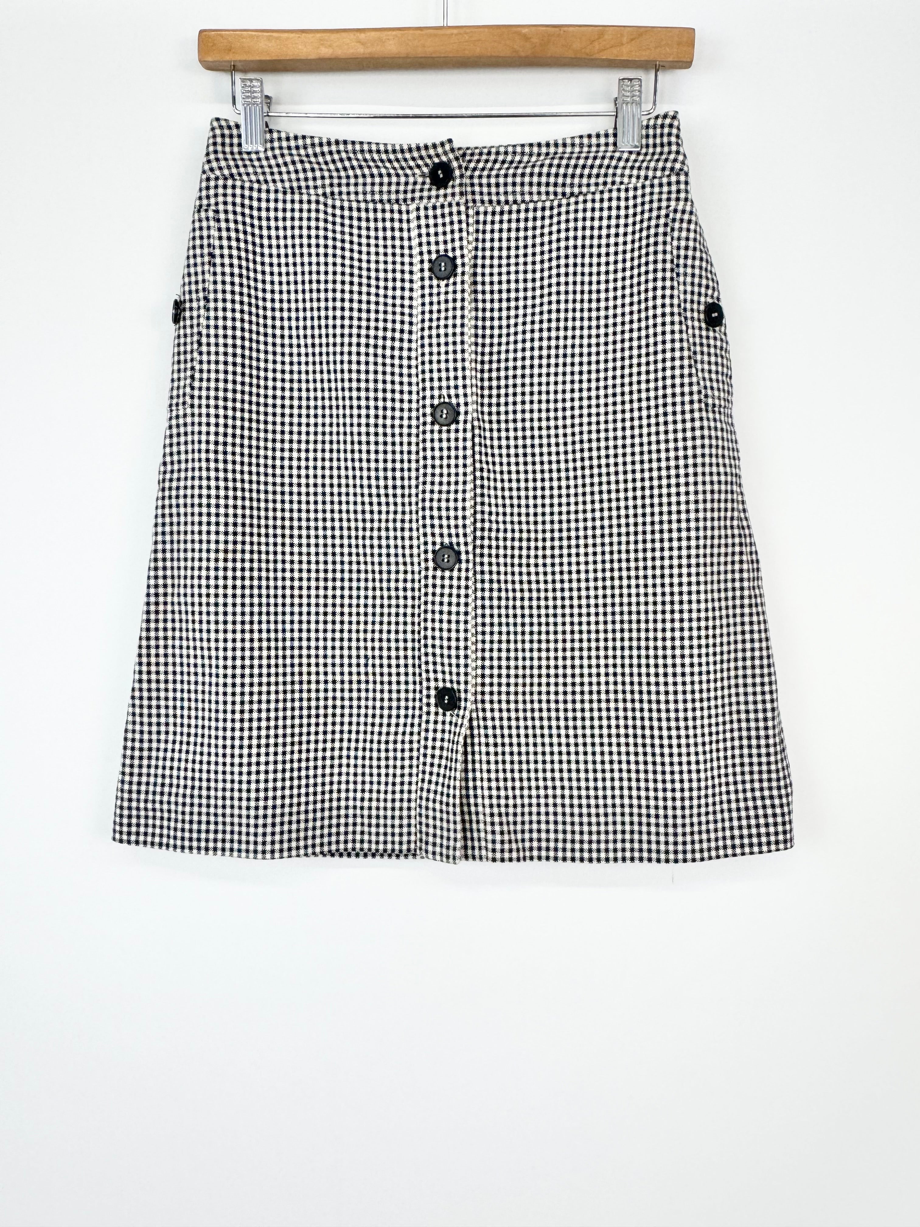 Black and white checkered skirt with buttons on a white background