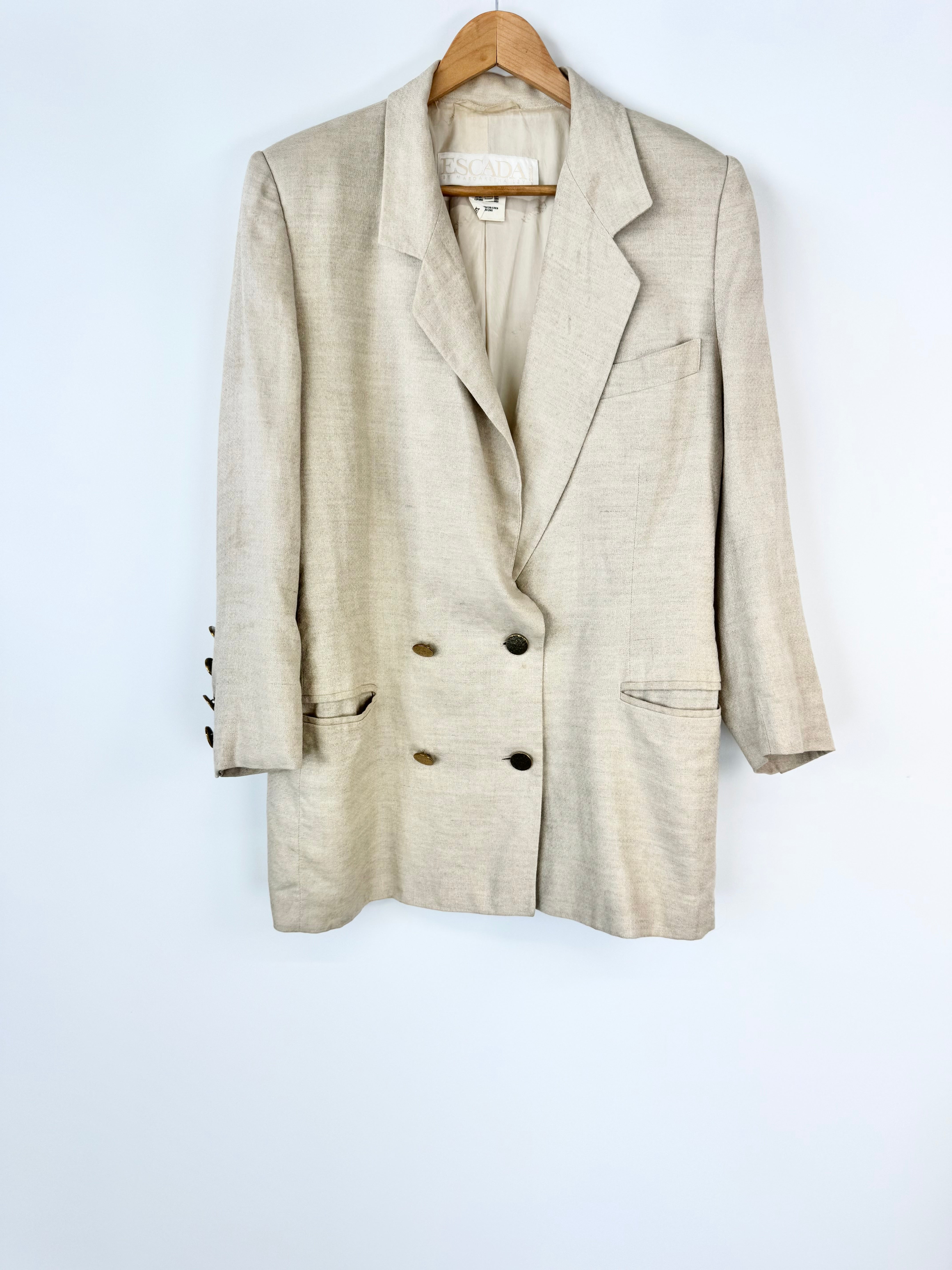 Beige blazer on a hanger against a white background