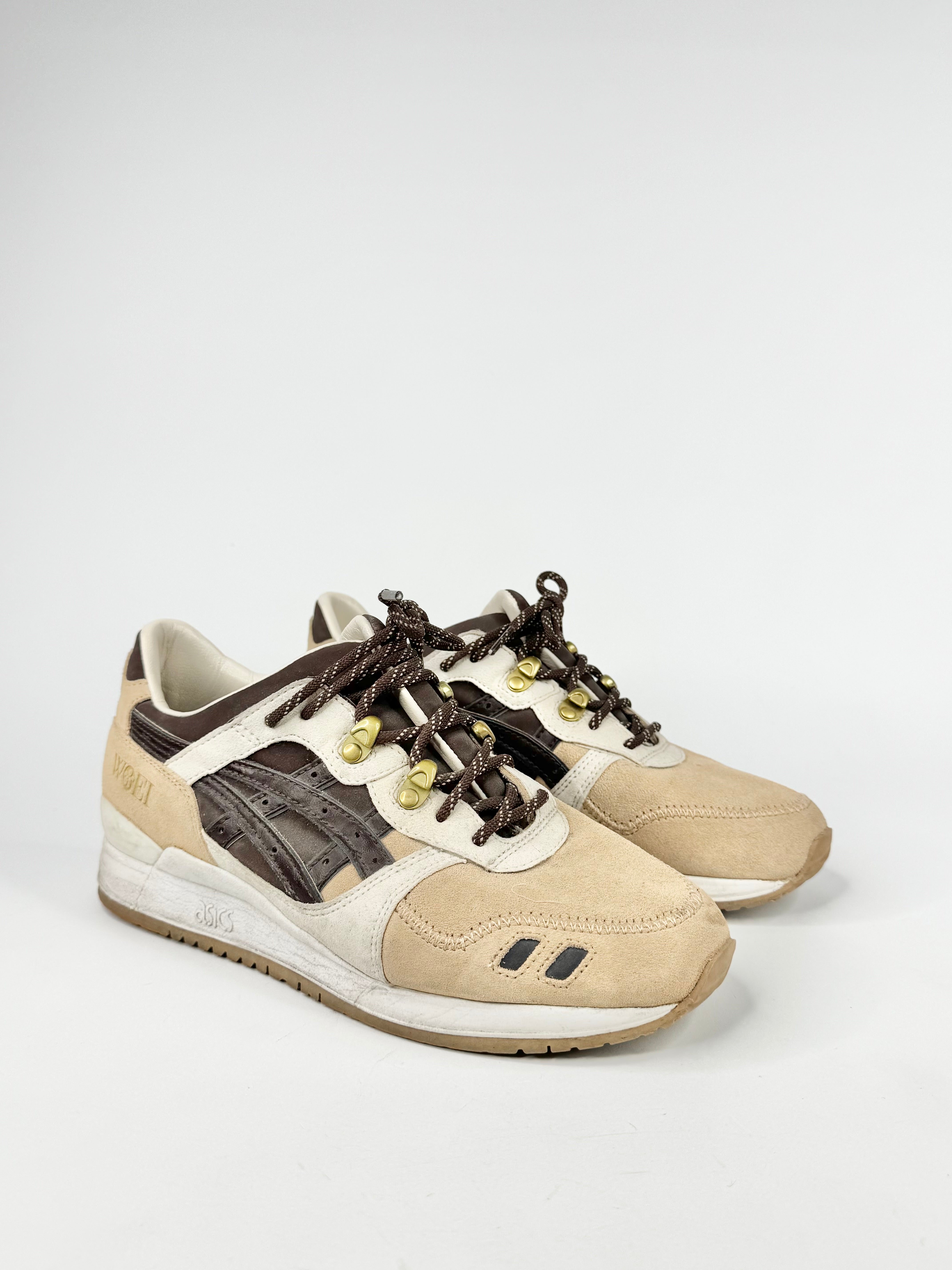 Pair of beige and brown sneakers on a white background