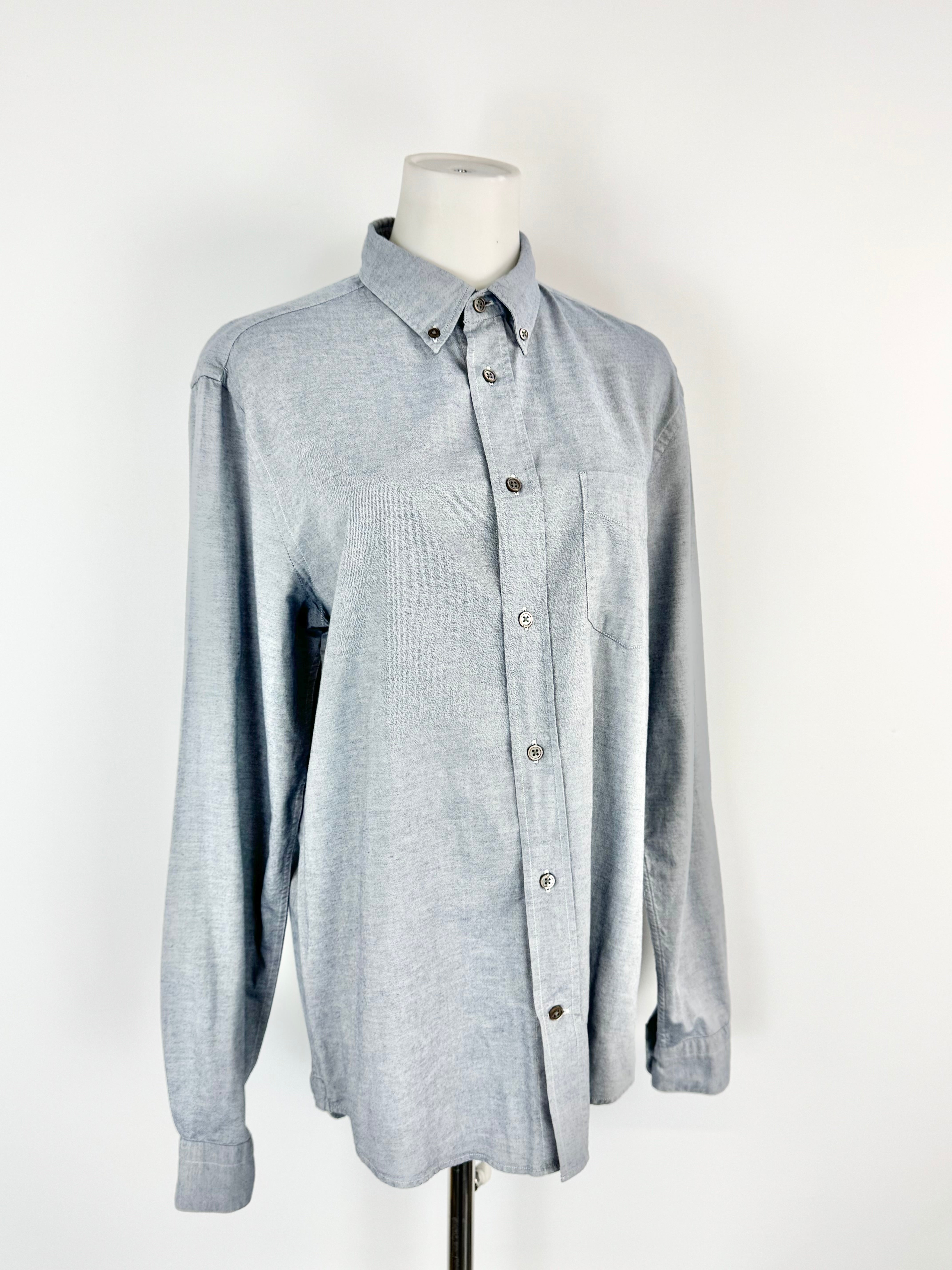 Blue button-up shirt on a mannequin against a white background