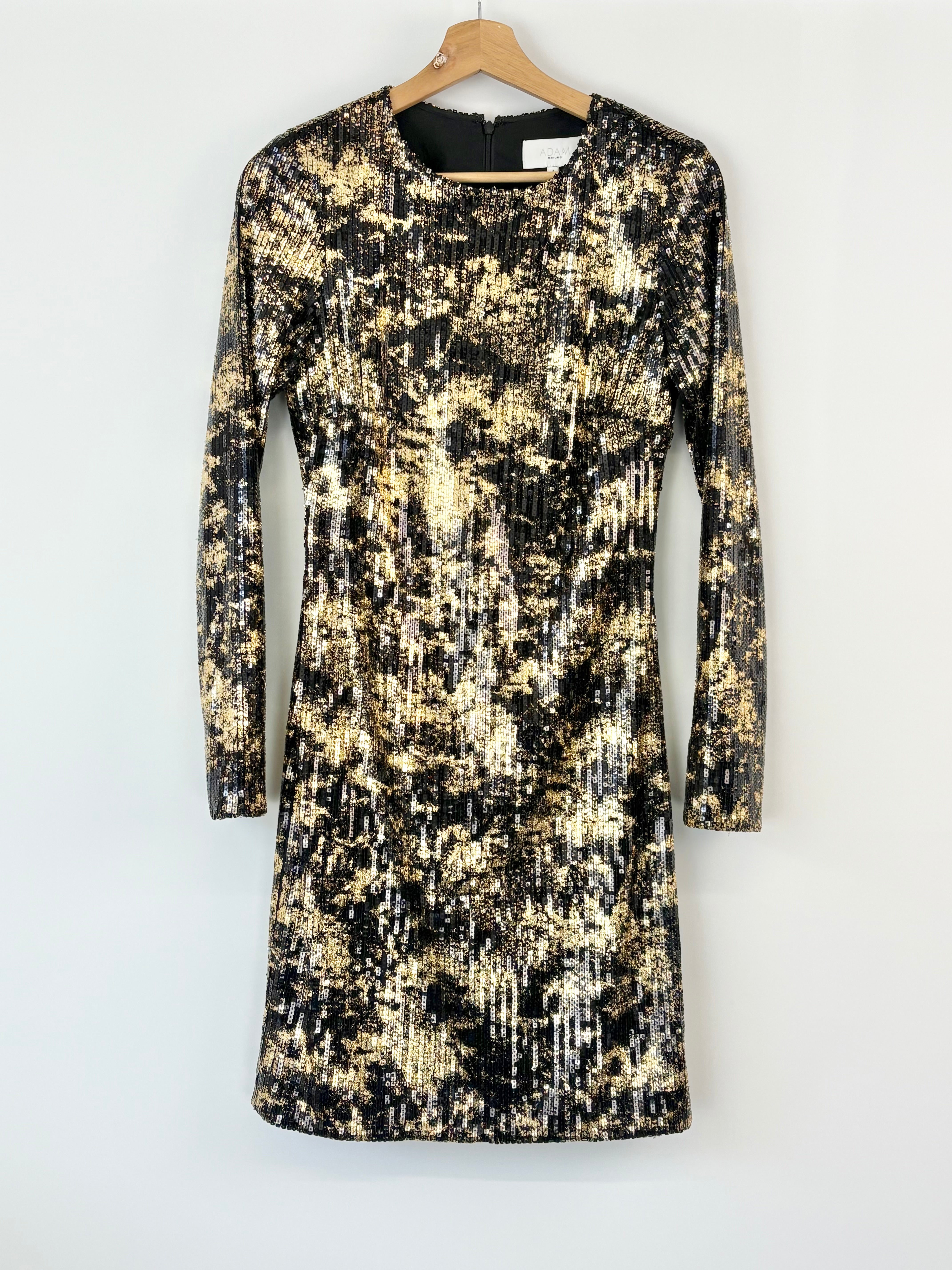 Black and gold patterned dress on a hanger against a white background