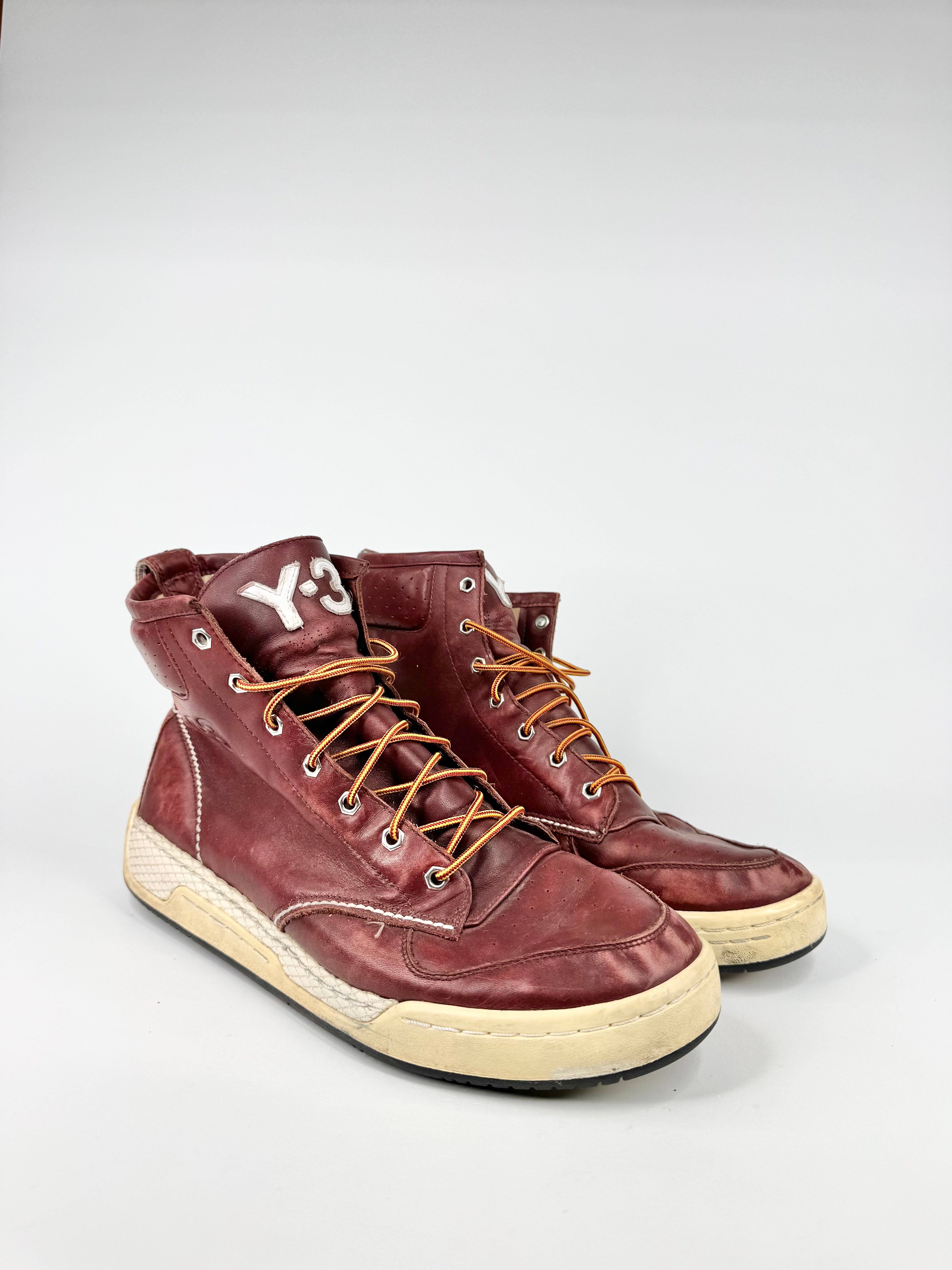 Pair of brown high-top sneakers with white soles on a light gray background