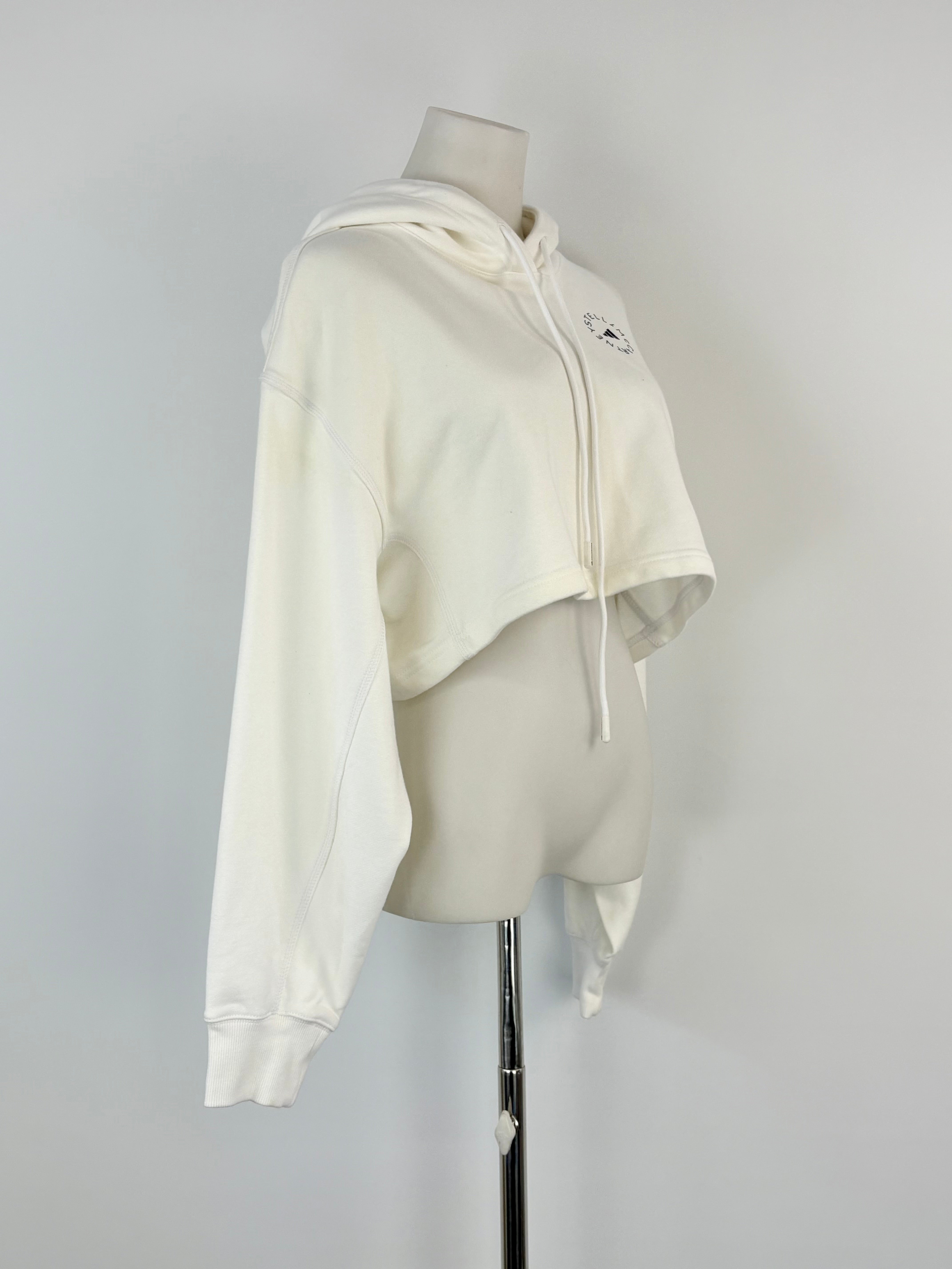 White cropped hoodie on a mannequin against a gray background