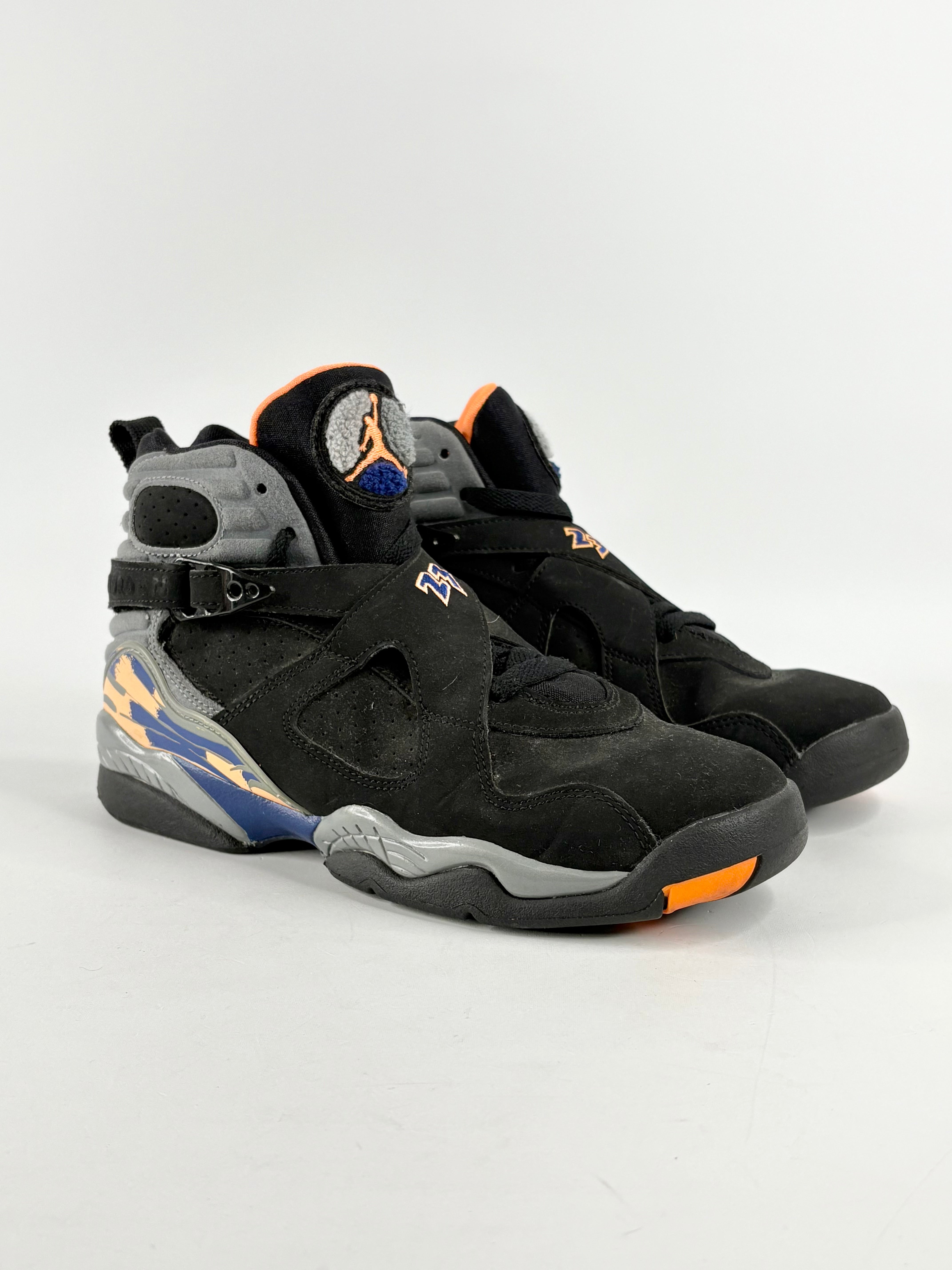 A pair of Air Jordan 8 Retro GS 'Phoenix Suns' sneakers in black with blue and orange accents, featuring a nubuck upper.