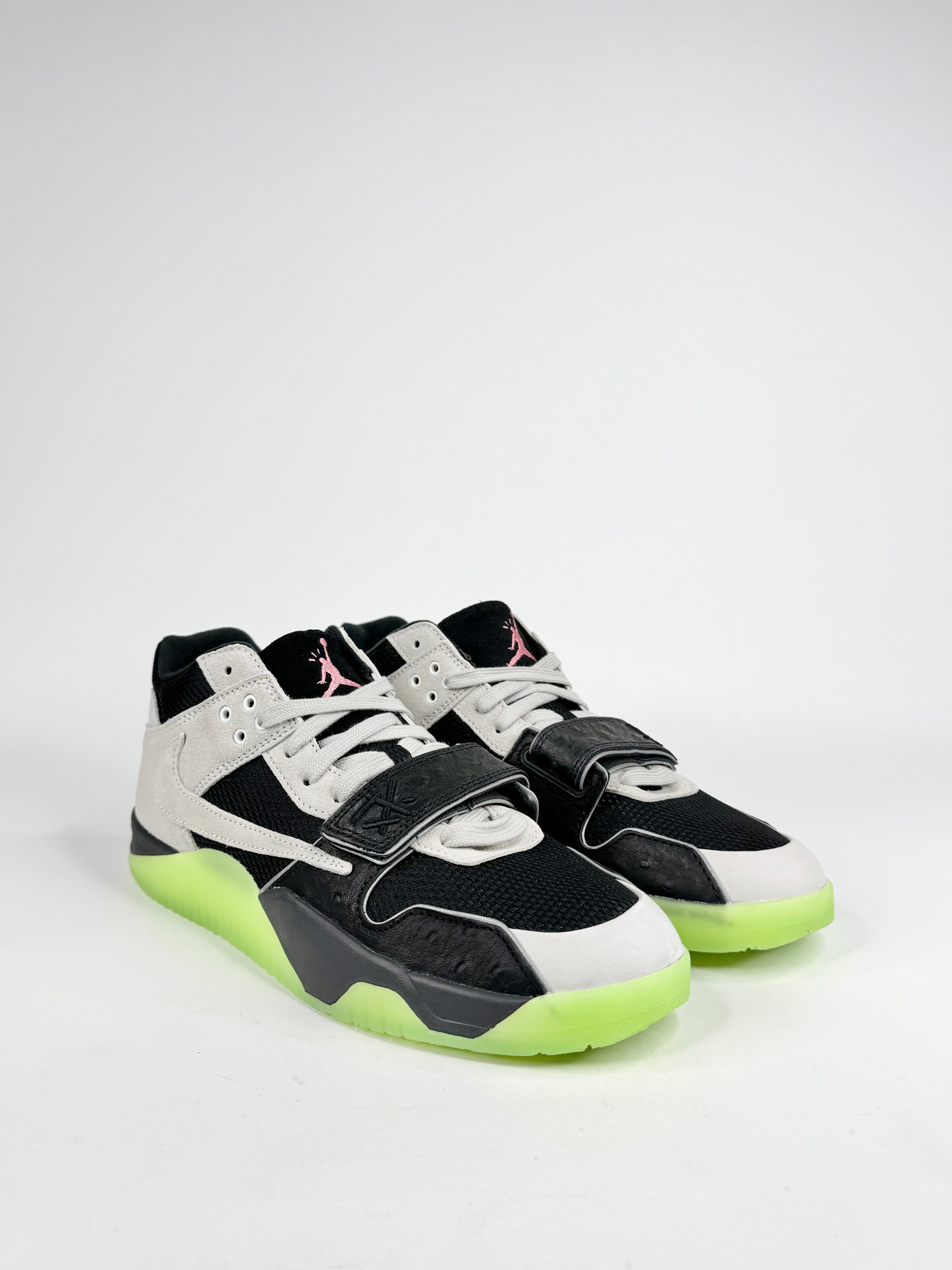 Black and white sneakers with green accents on a light gray background