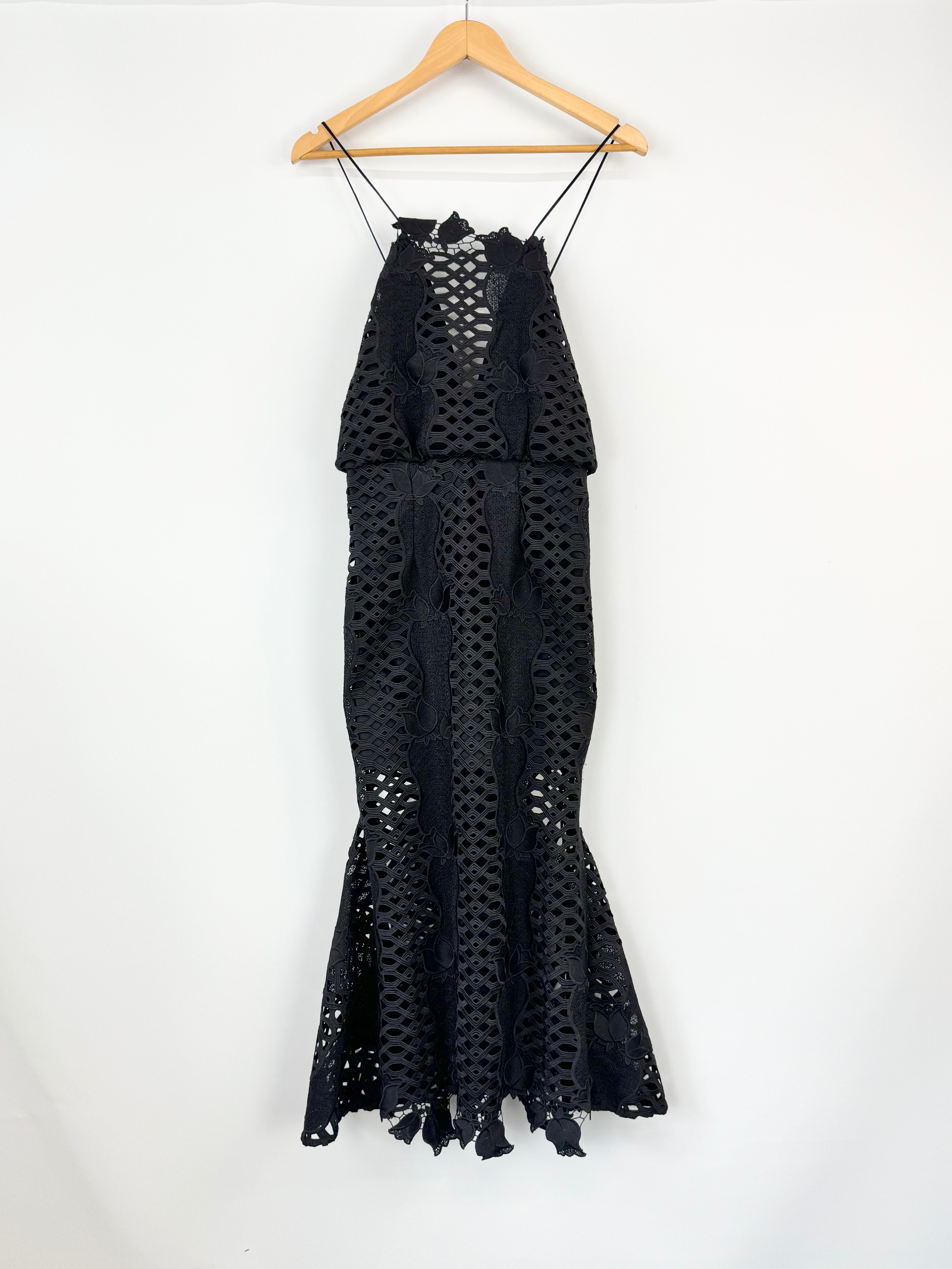 Black lace dress on a wooden hanger against a white background