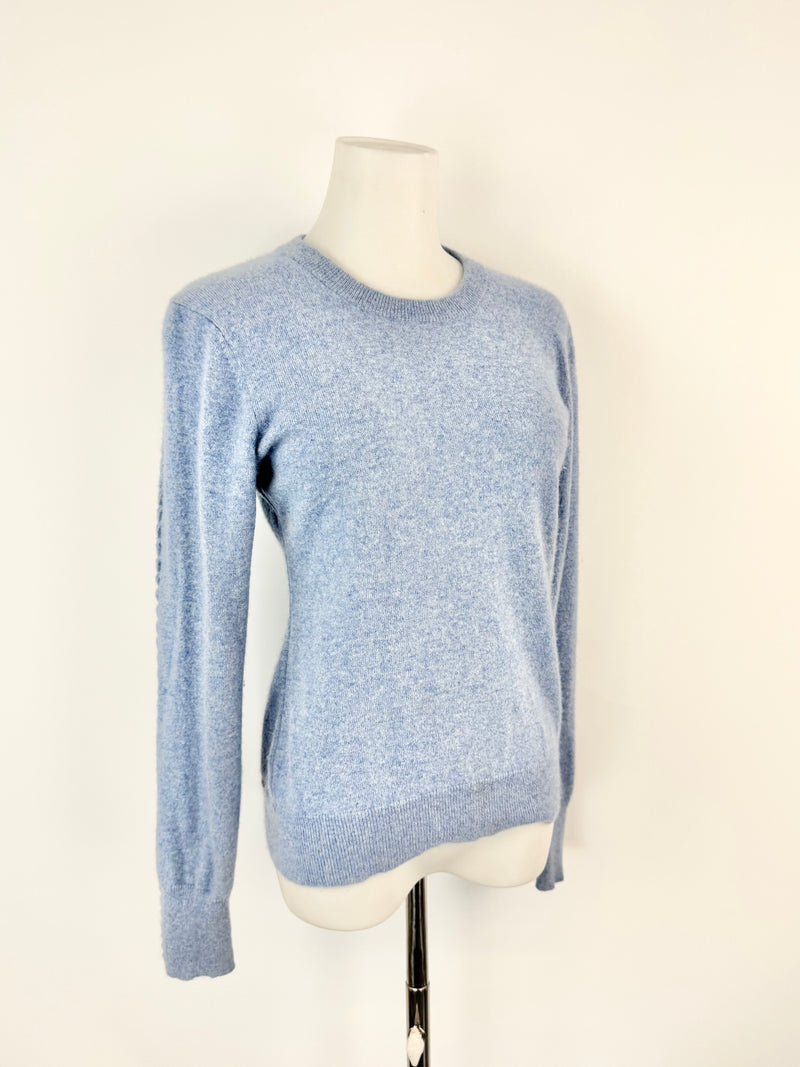 Blue sweater on a mannequin against a white background