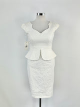 A white cream-colored dress with a sweetheart neckline, cap sleeves, and a peplum waist, displayed on a mannequin.